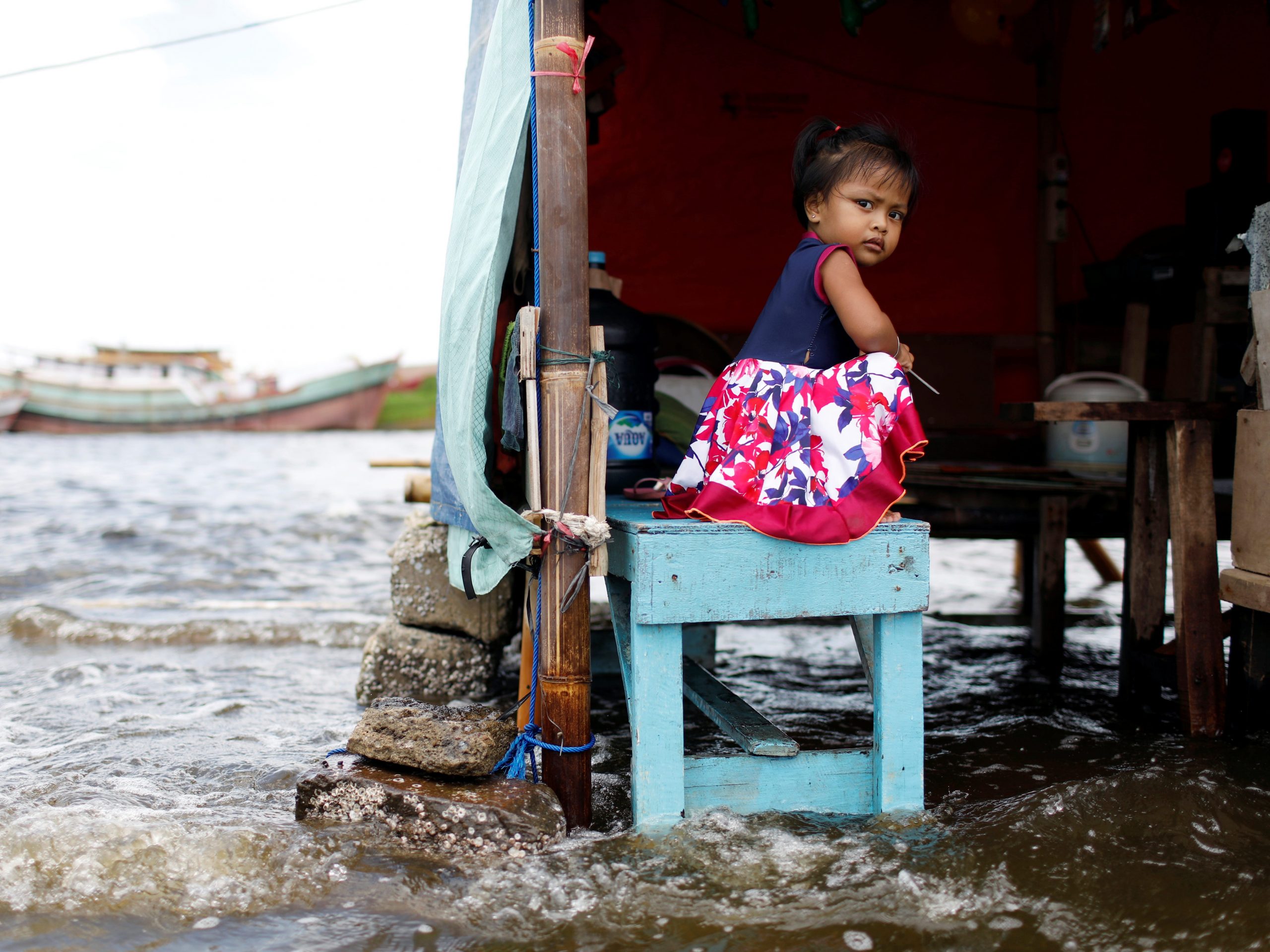 rising seas surround little girl on bench