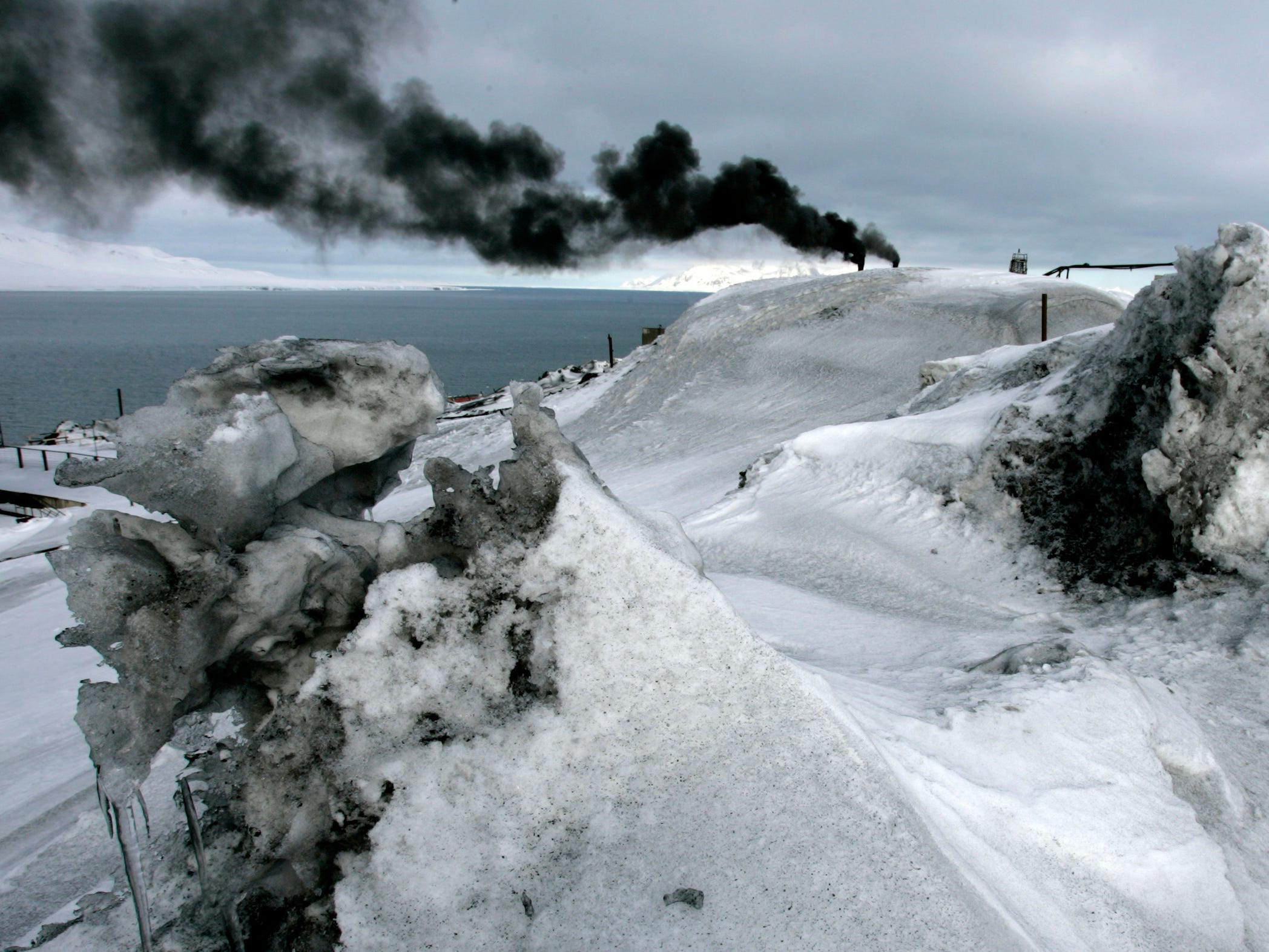 black smoke plume above darkened snow