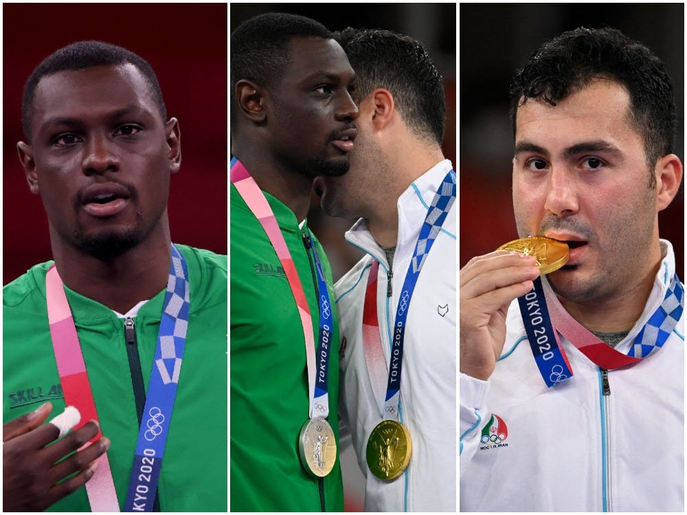 Tareg Hamedi of Saudi Arabia, and Sajad Ganjzadeh of Iran, collect their medals after the karate final.