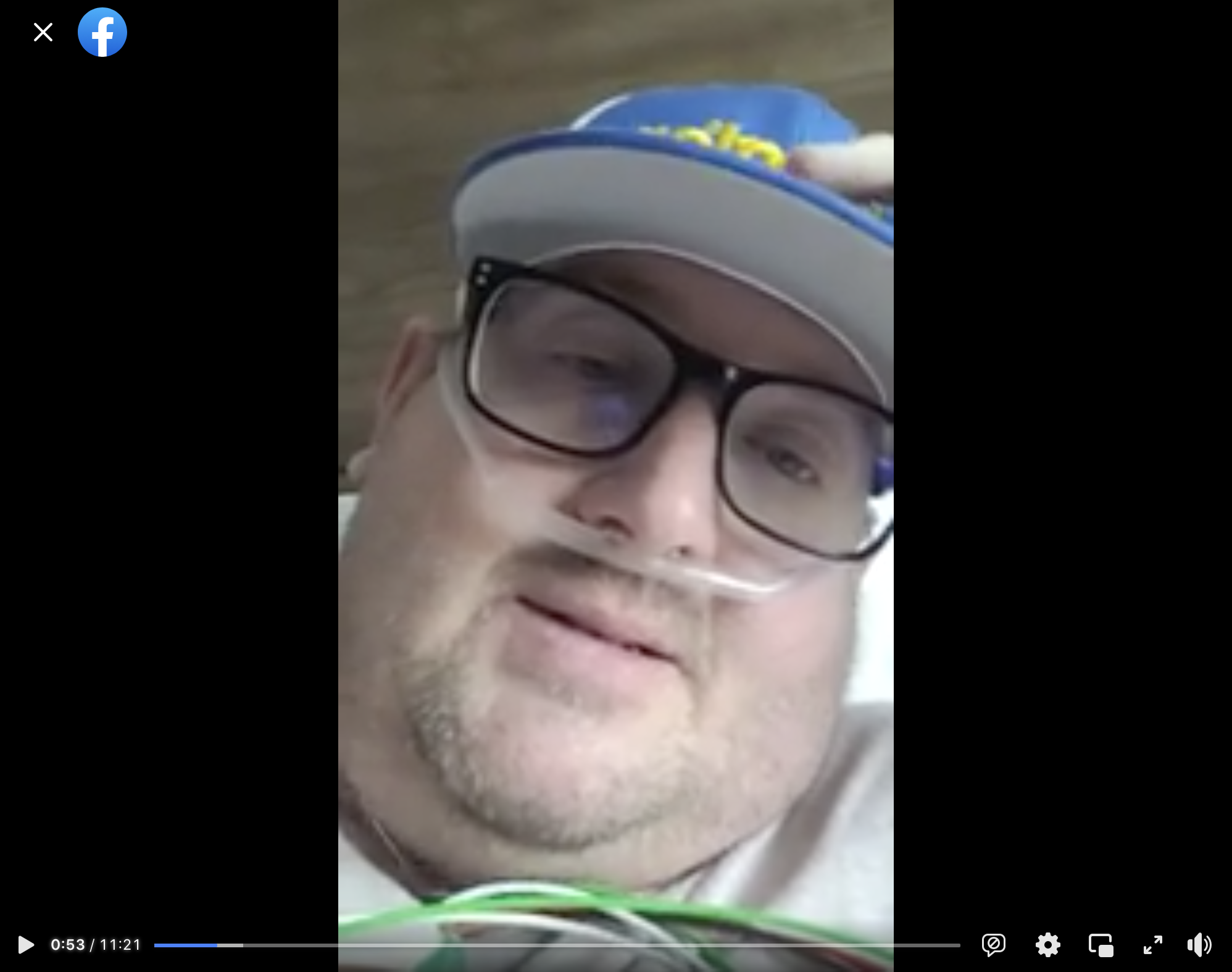 A vertical video posted to Facebook with a man wearing a blue cap and hooked up to supplemental oxygen.