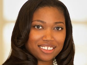 Melinda Hightower of UBS smiles in front of a bright background, wearing pearls and a black top.