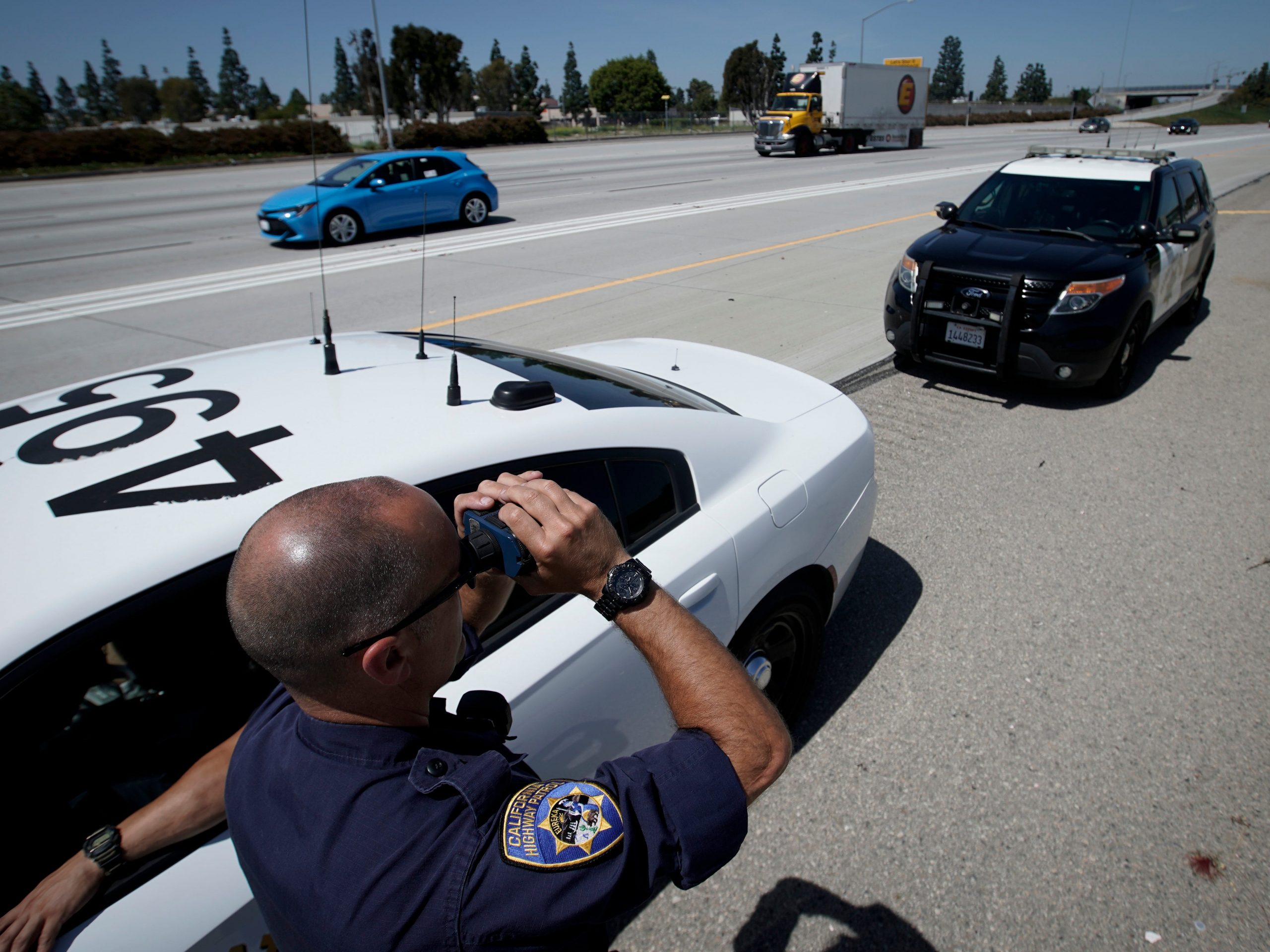 California Highway Patrol officer Matthew Musselmann uses a lidar gun for speed detection along Interstate 5 freeway, Thursday, April 23, 2020, in Anaheim, Calif.