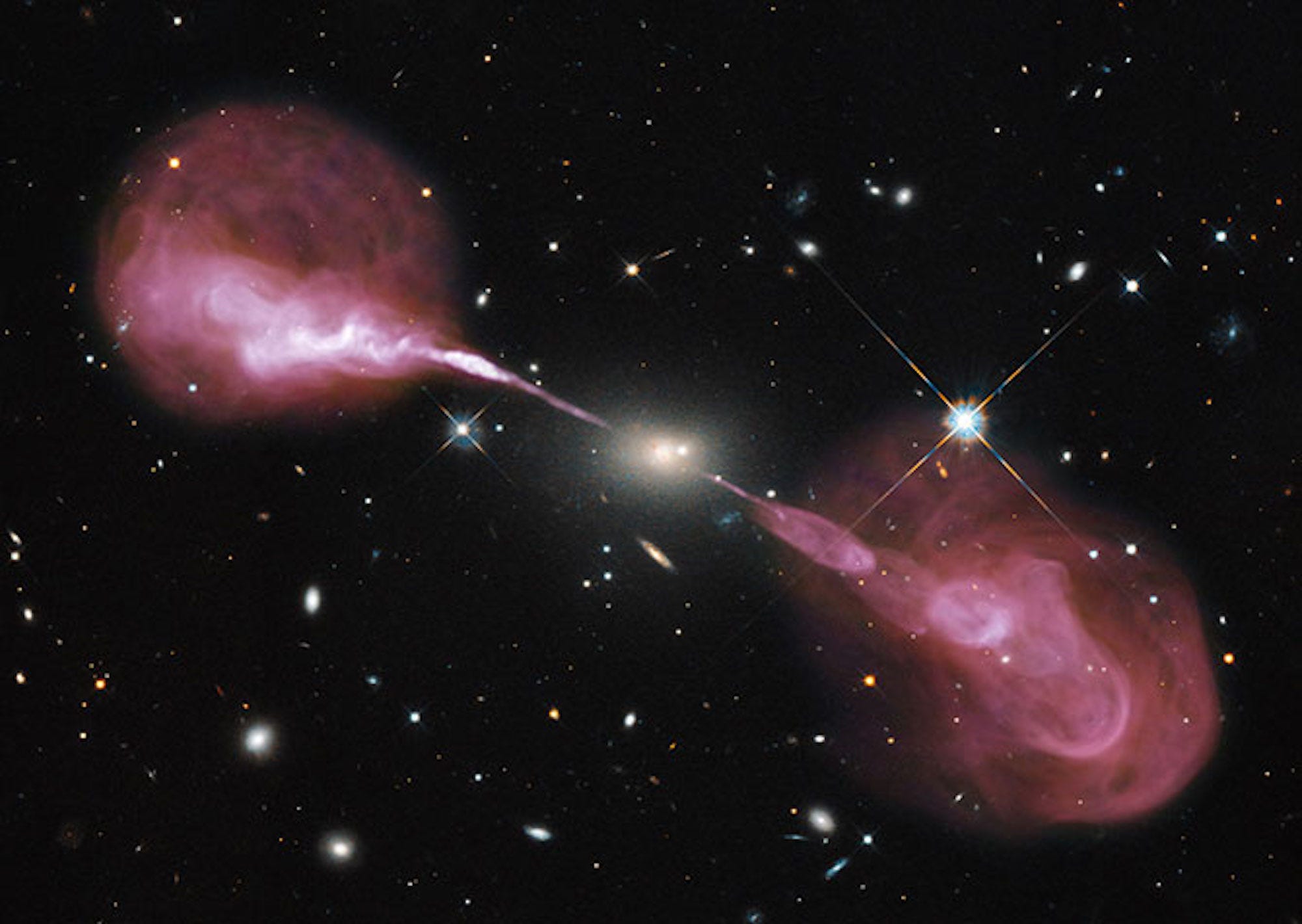 a picture of radio galaxy Hercules A shows the galaxy in the center and two plumes of matter jetting out of it straight either way