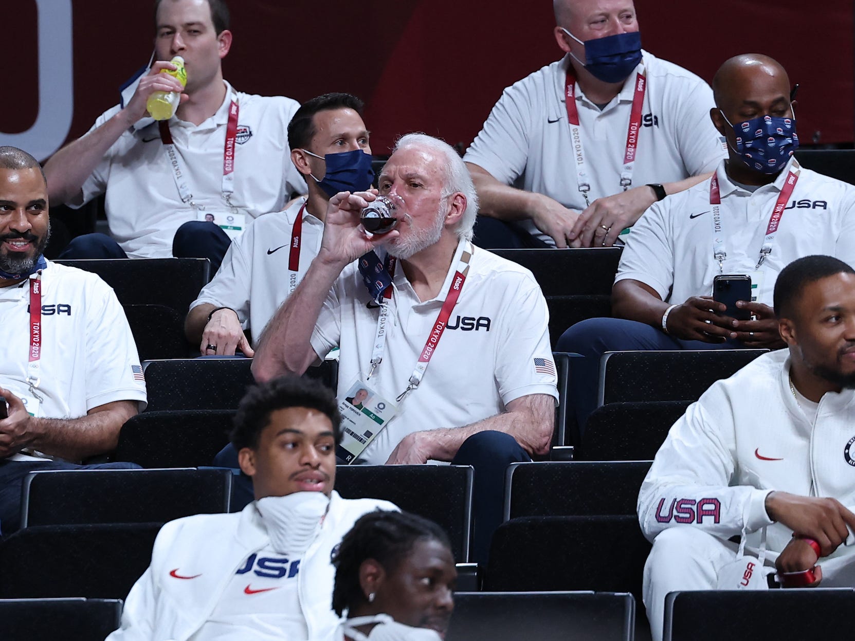 Gregg  Popovich drinks wine in the stands during the Olympics men's basketball bronze medal match.