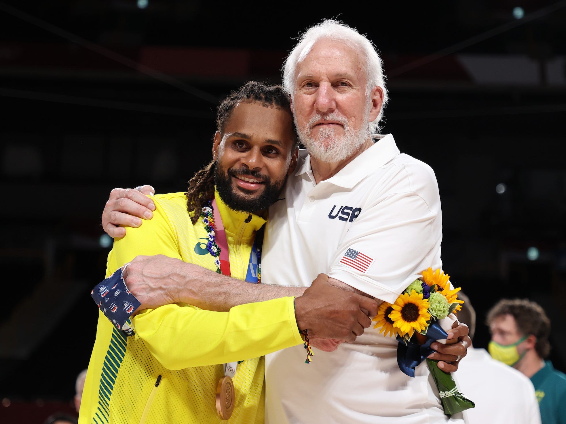Patty Mills and Gregg Popovich hug at the Tokyo Olympics.