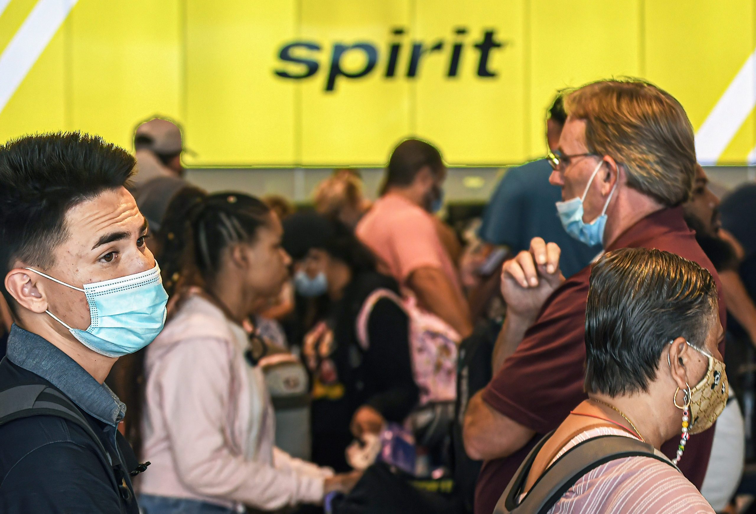 Passengers wait in line at the Spirit Airlines check-in counter at Orlando International Airport on the sixth day the airline has cancelled hundreds of flights.