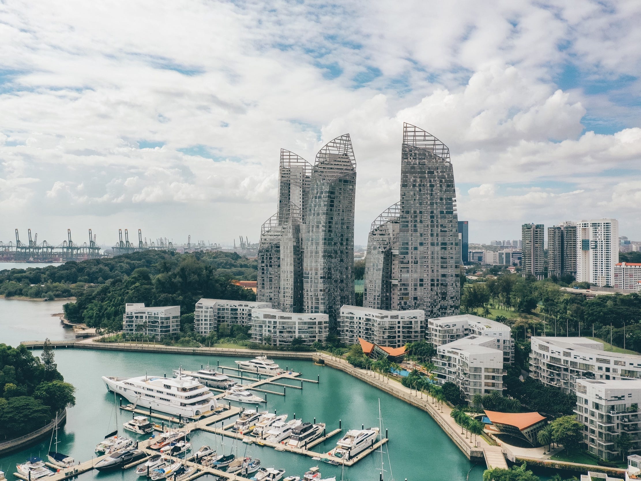 a view of luxury condominiums along the water with boats in foreground in singapore
