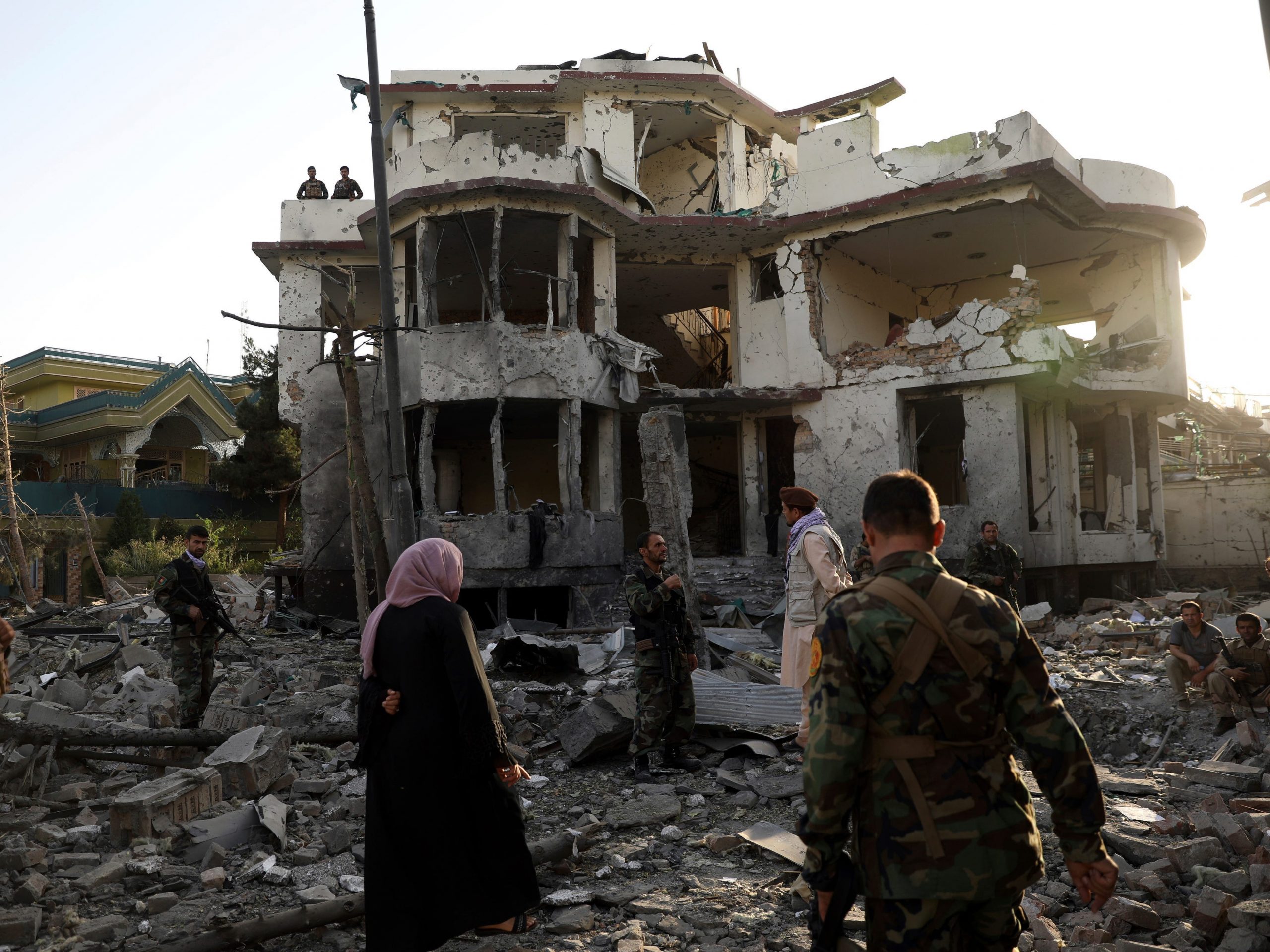 Afghan security personnel inspect a damaged building in the aftermath of an attack in Kabul, Afghanistan, Wednesday, Aug. 4, 2021. A powerful explosion rocked an upscale neighborhood of Afghanistan's capital Tuesday in an attack that apparently targeted the country's acting defense minister.