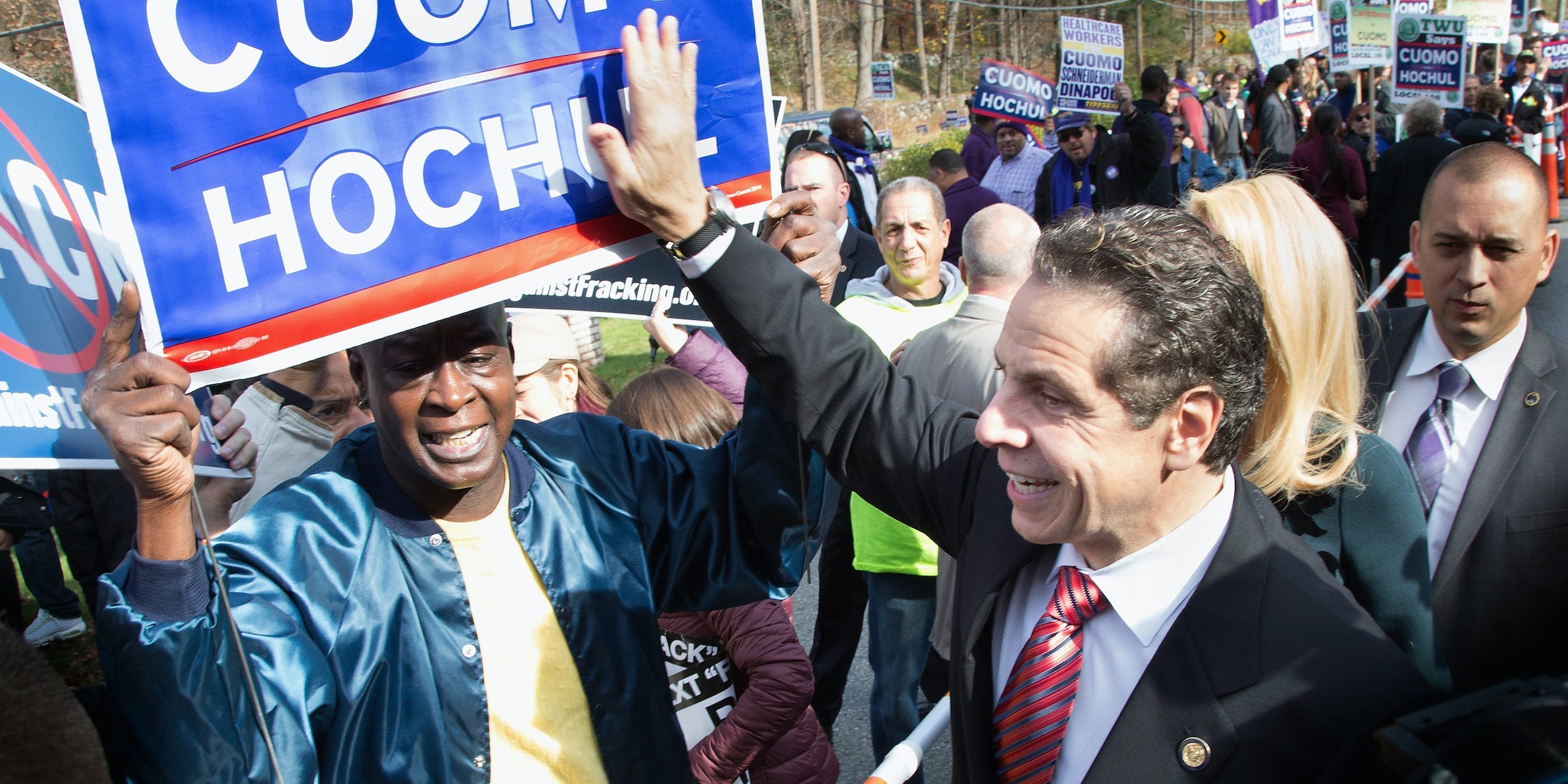 Andrew Cuomo greets voters on a rope line and taps a Cuomo-Hochul sign during the 2014 gubernatorial campaign in New York.