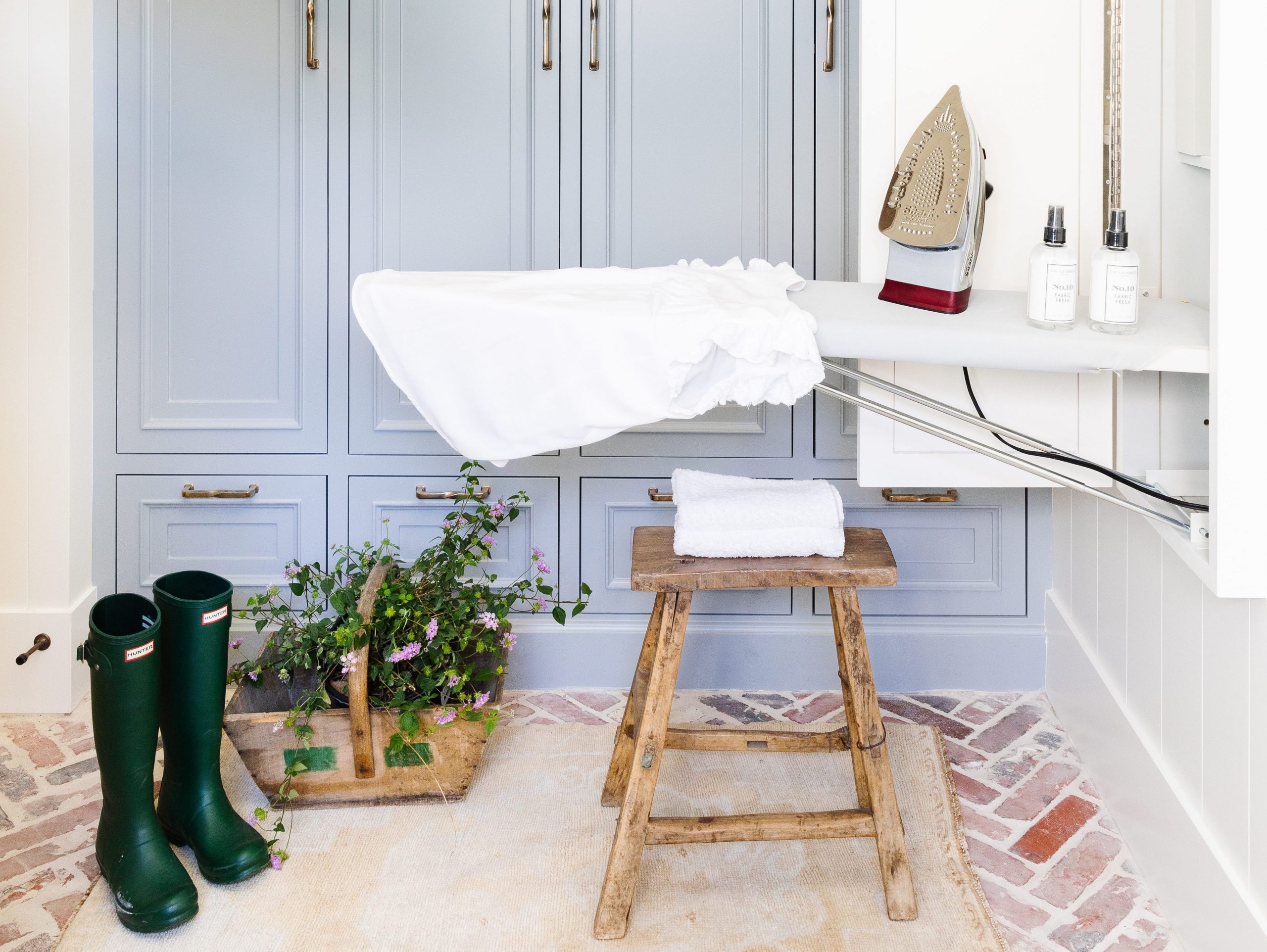 Room with light blue cabinets and a foldout ironing board.