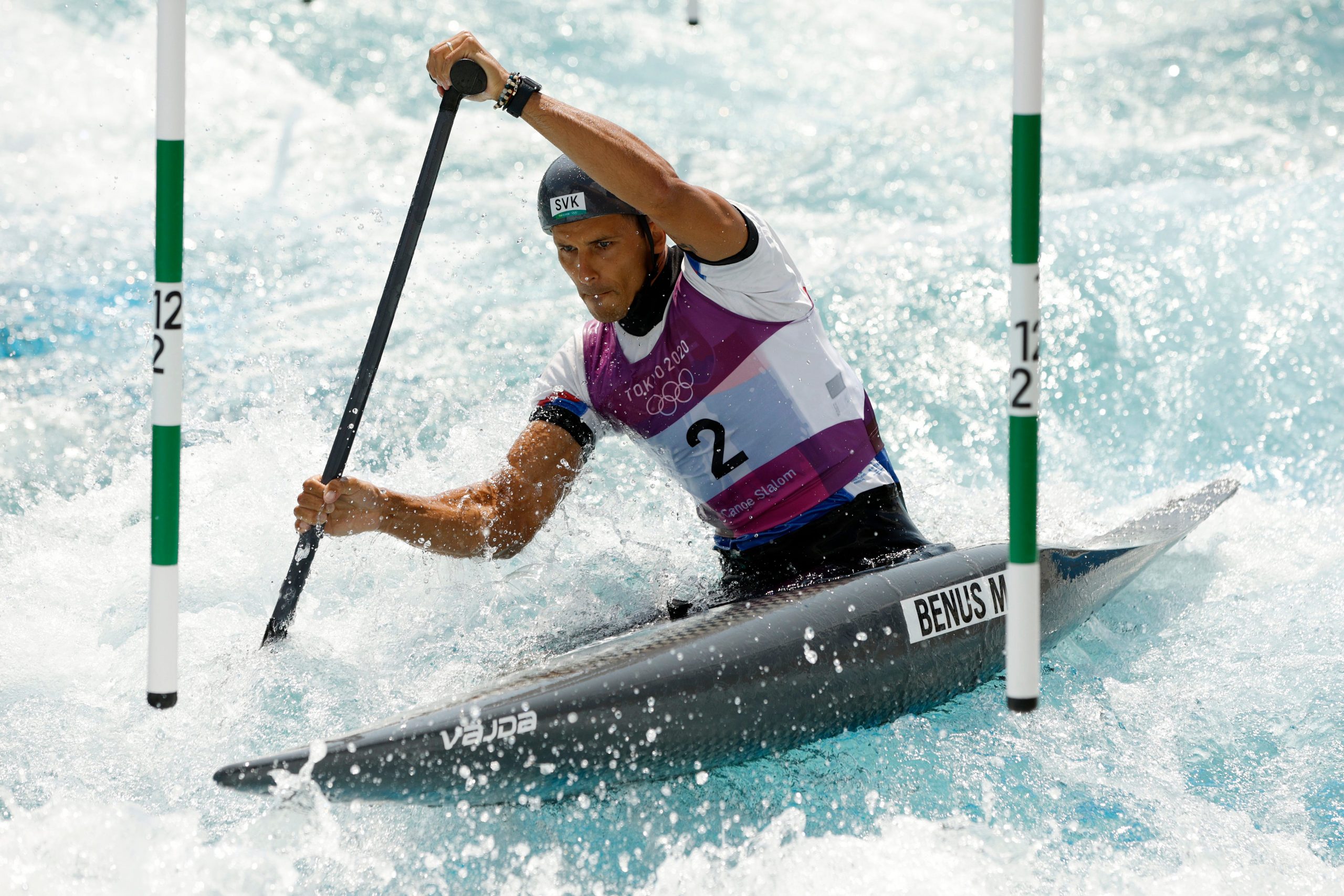 Canoeist Matej Beňuš paddles and propels his boat through a course at the Tokyo Olympics.