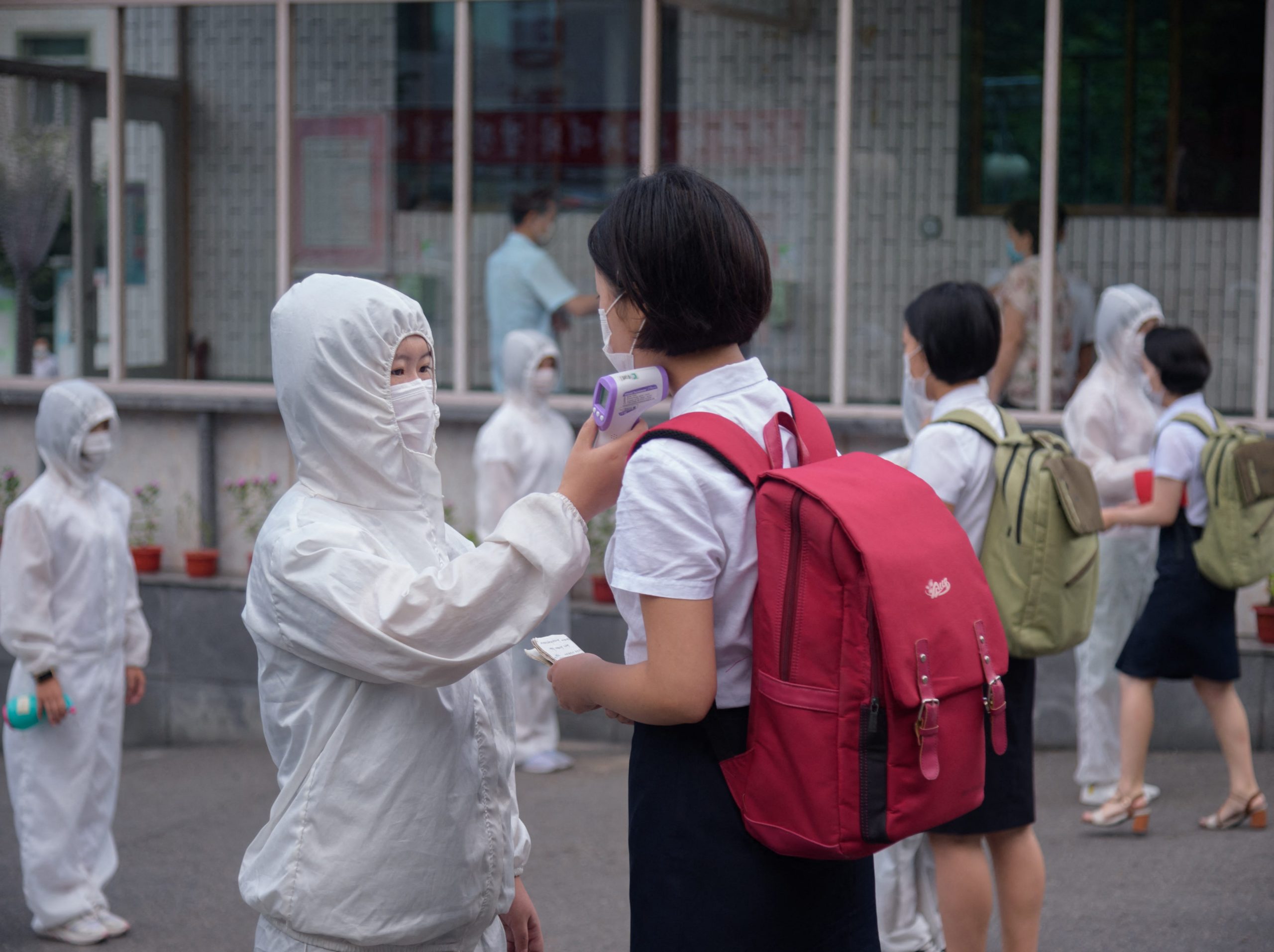 Students of the Pyongyang Jang Chol Gu University of Commerce undergo temperature checks before entering the campus, as part of preventative measures against COVID-19, in Pyongyang on August 11, 2021.