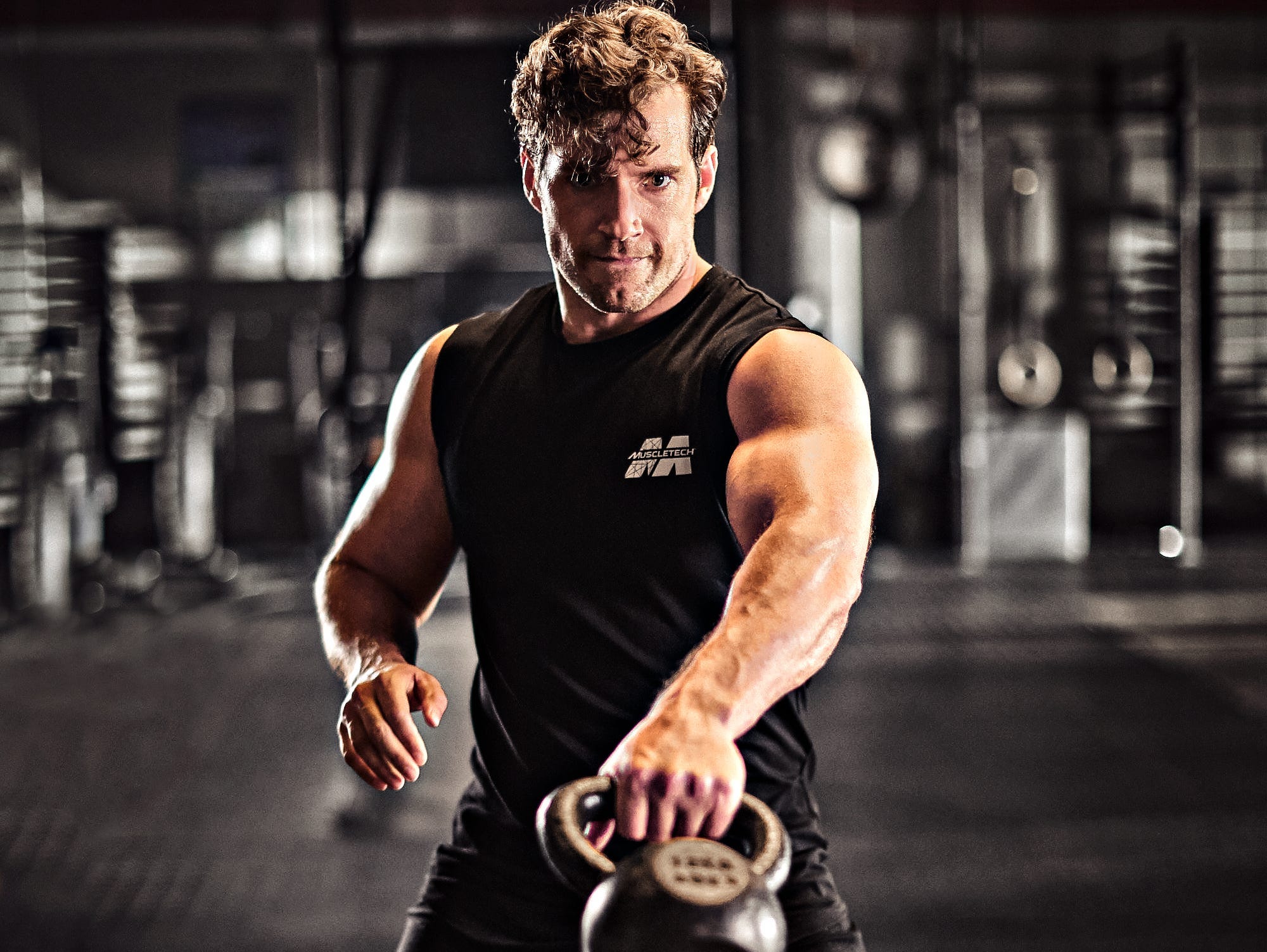 Henry Cavill swinging a kettlebell.