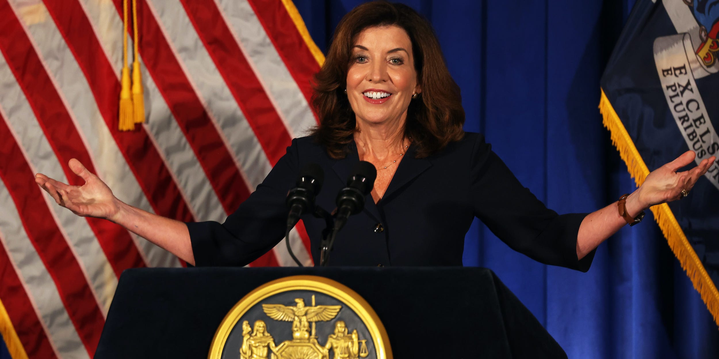 Kathy Hochul raises her arms at her first press conference since Andrew Cuomo resigned as New York governor.