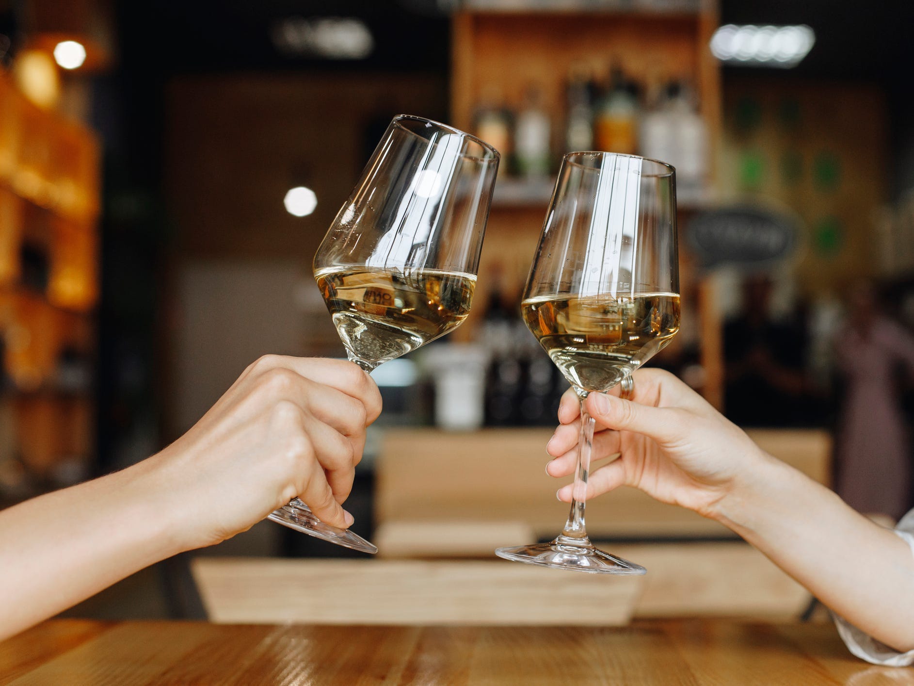 People toasting with white wine.