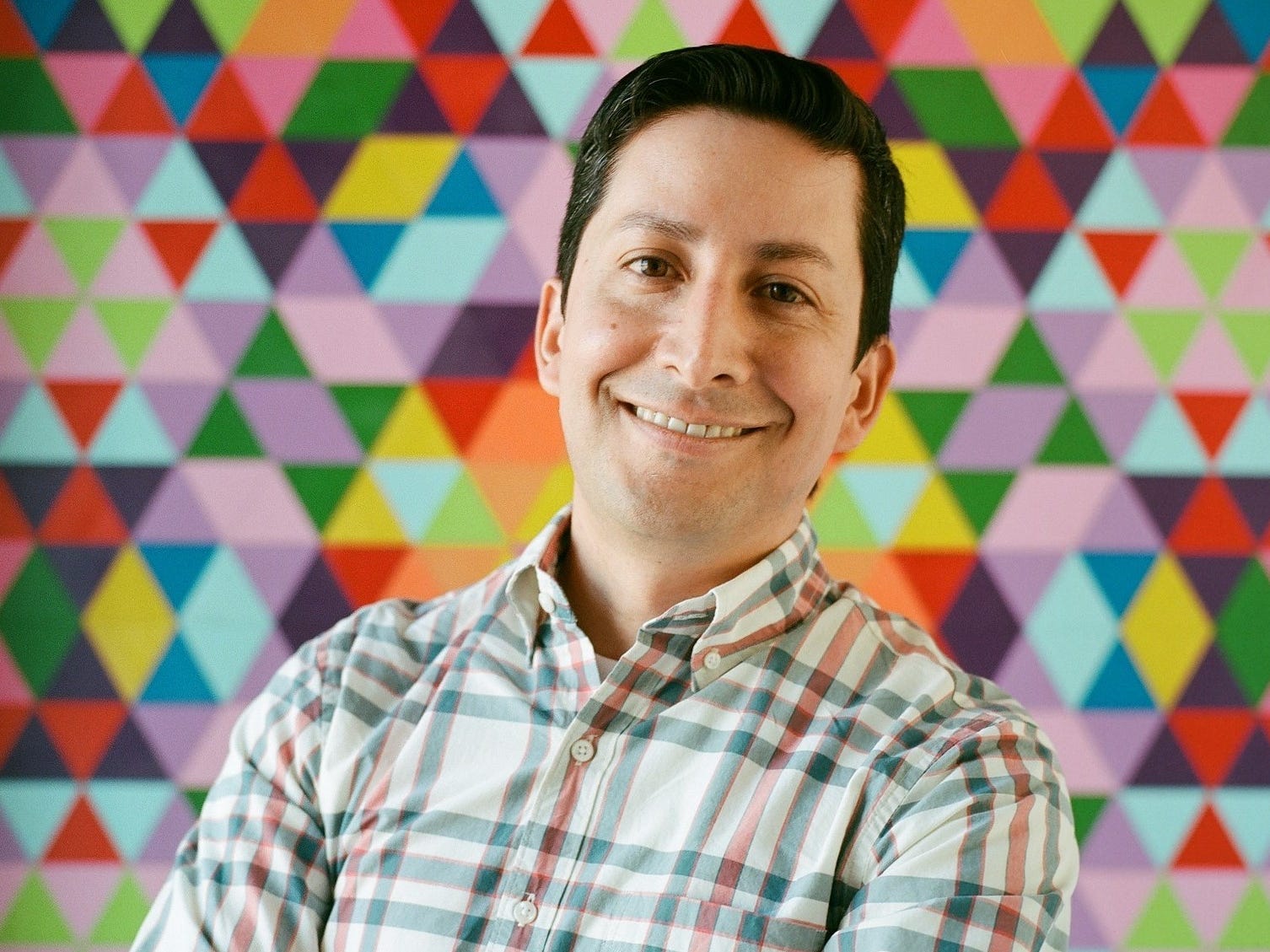 Justin Antony, Instagram's head of creators smiles with his arms crossed.
