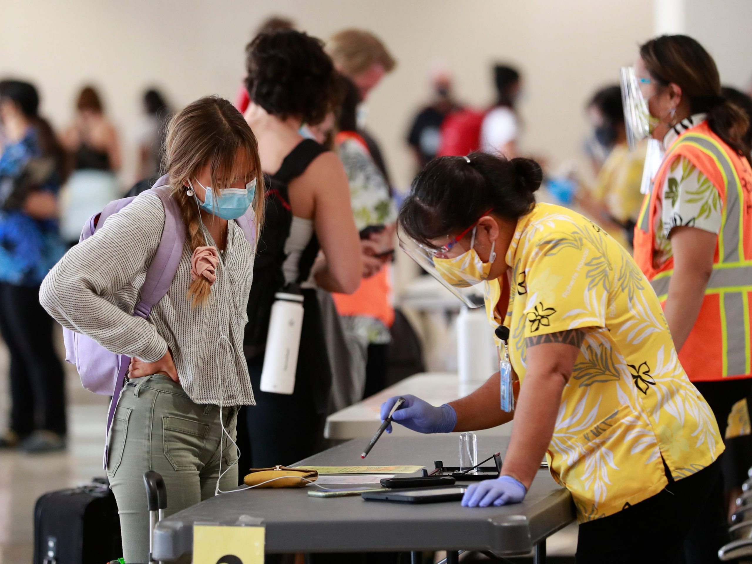 A traveler is assisted by a state official at the Daniel K. Inouye International Airport Thursday, Oct. 15, 2020, in Honolulu.