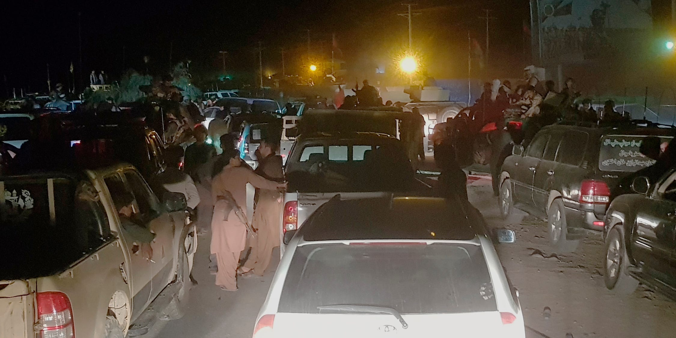 People and cars on a dark street