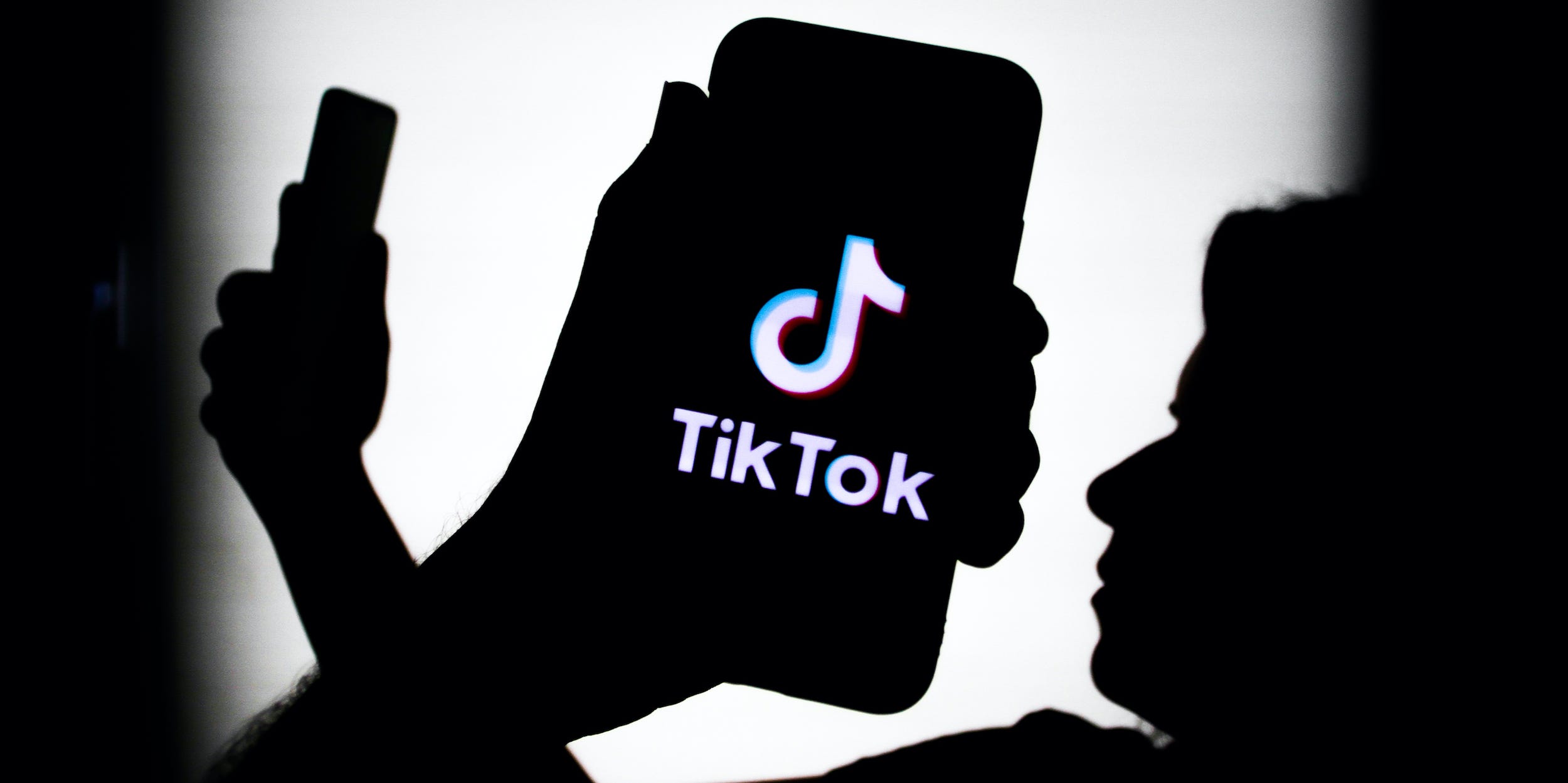 silhouettes of people looking at TikTok on phones