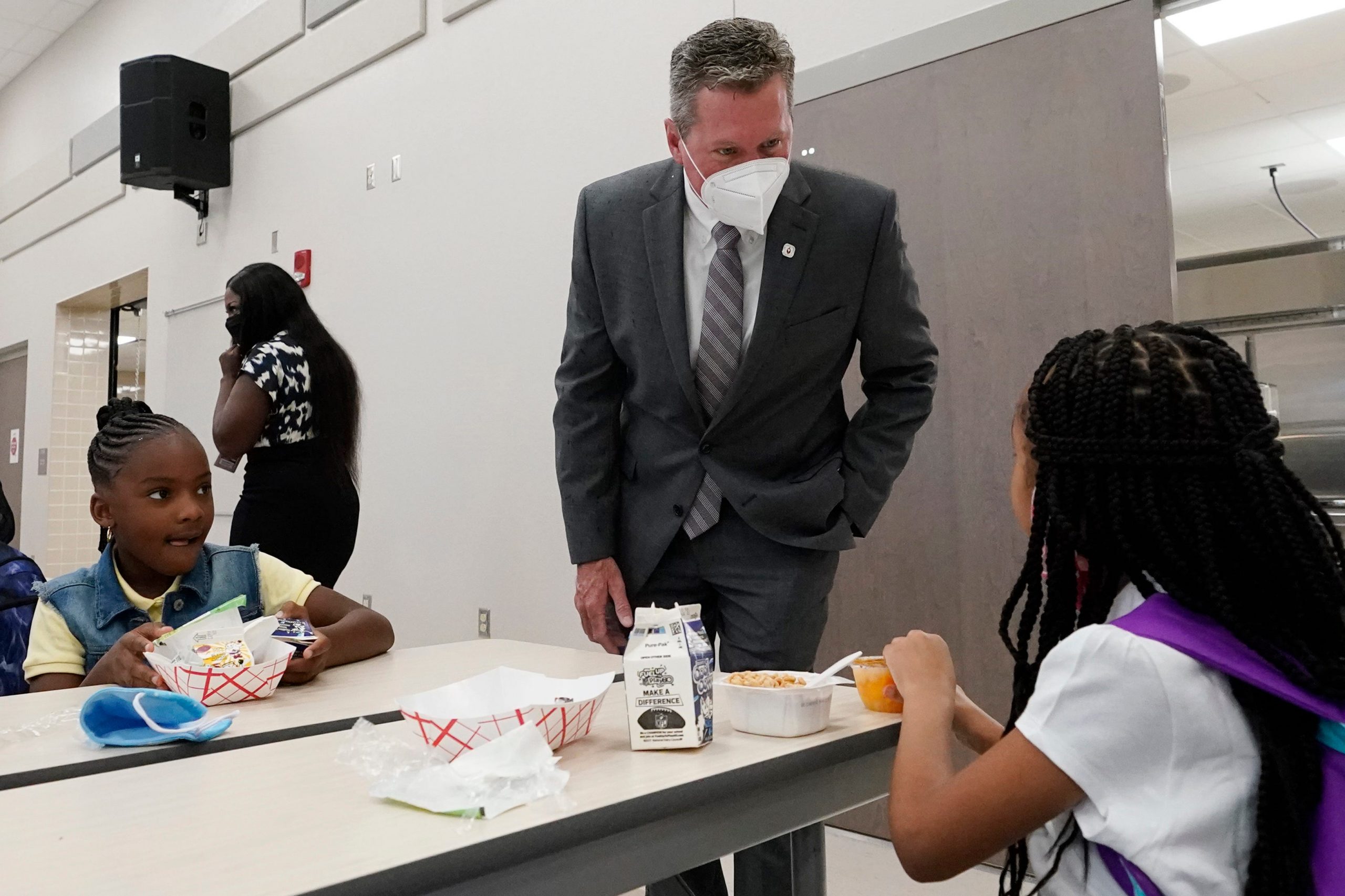 Palm Beach County Superintendent of Schools Mike Burke chats with students as they eat breakfast