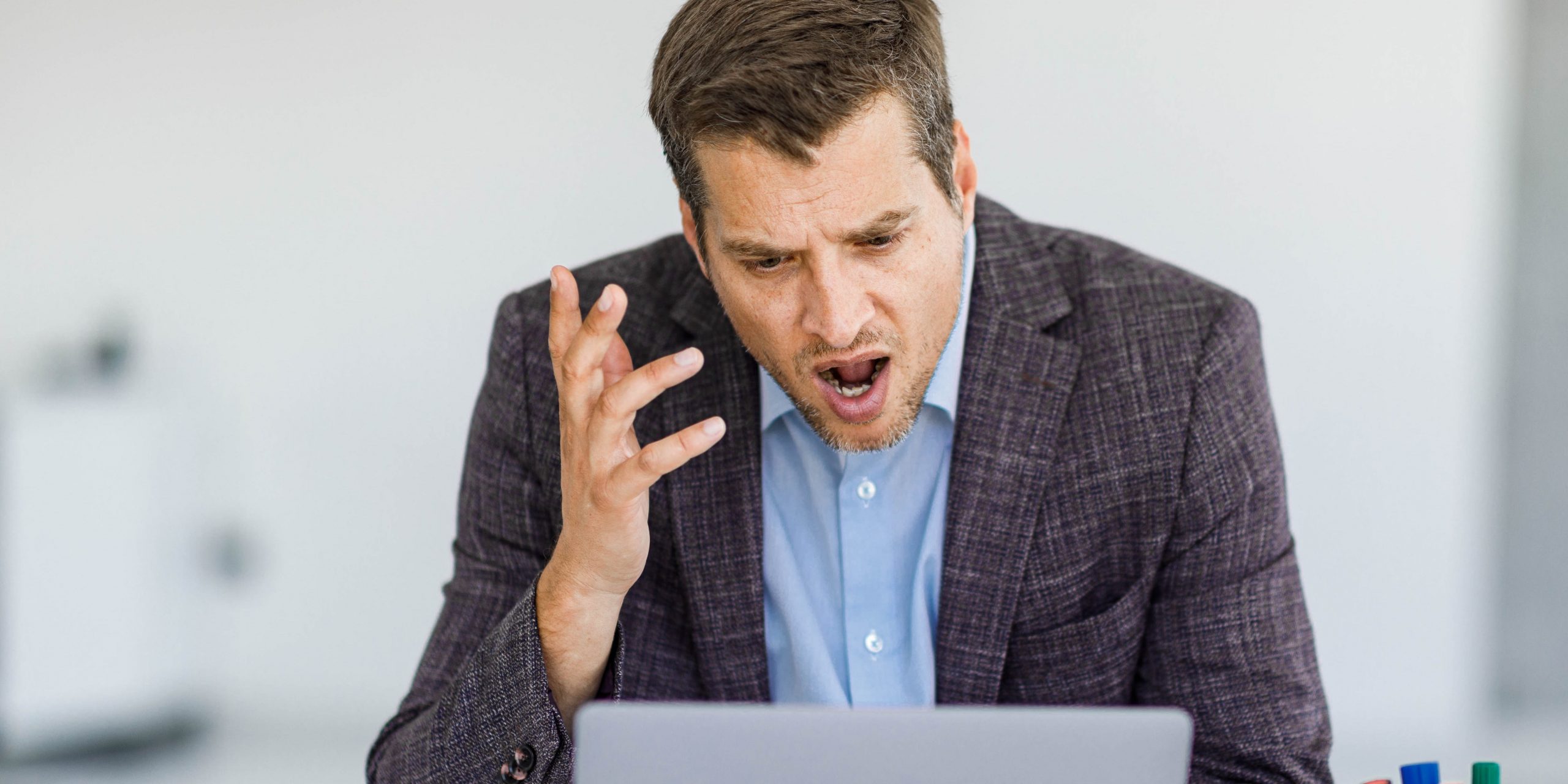 Angry man arguing during conference call on laptop