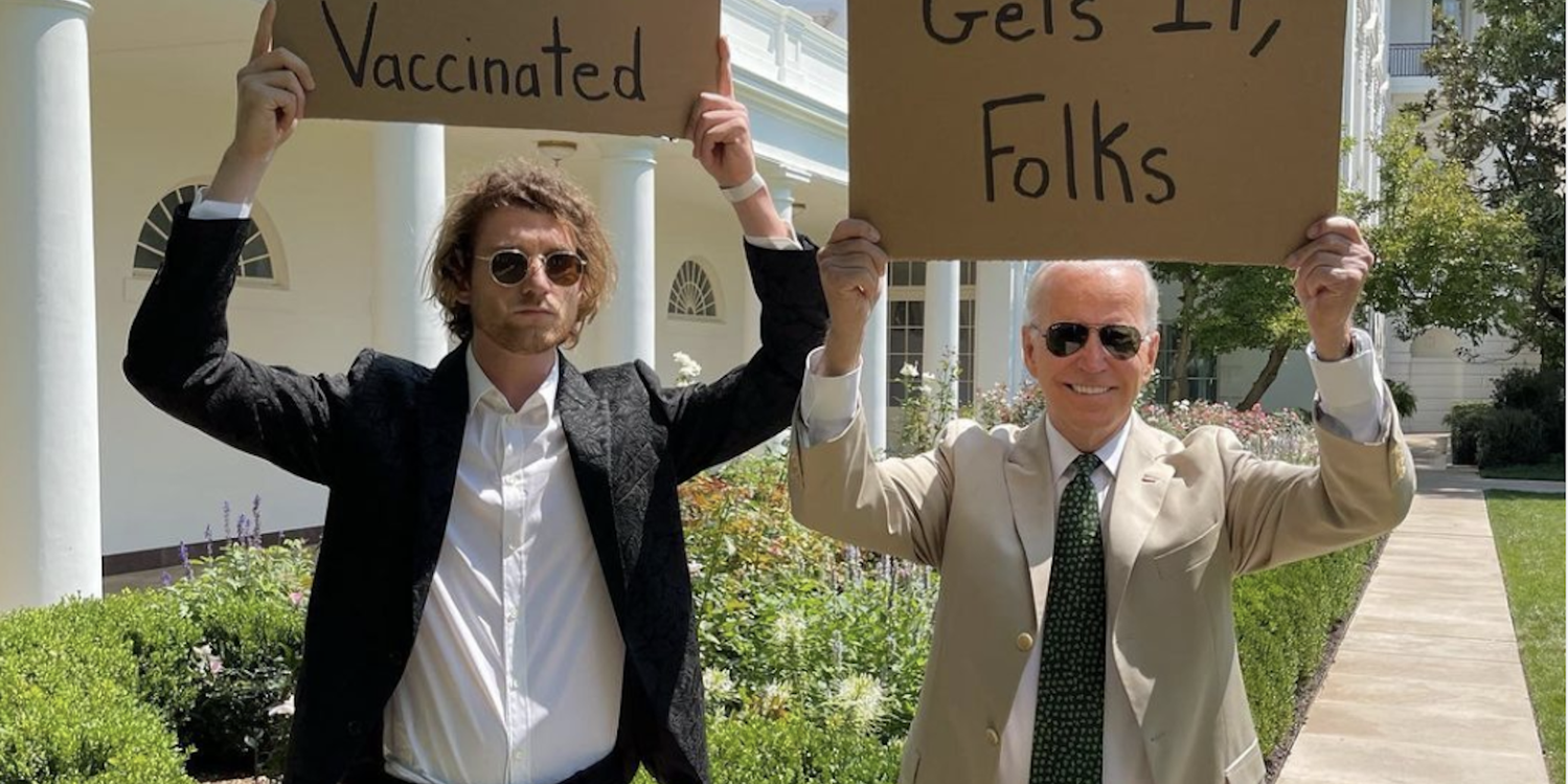 Instagram influencer Sam Phillips (left) holds a cardboard sign reading "let's look out for each other and get vaccinated" with President Joe Biden (right), who is also holding a cardboard sign, reading "this dude gets it, folks."