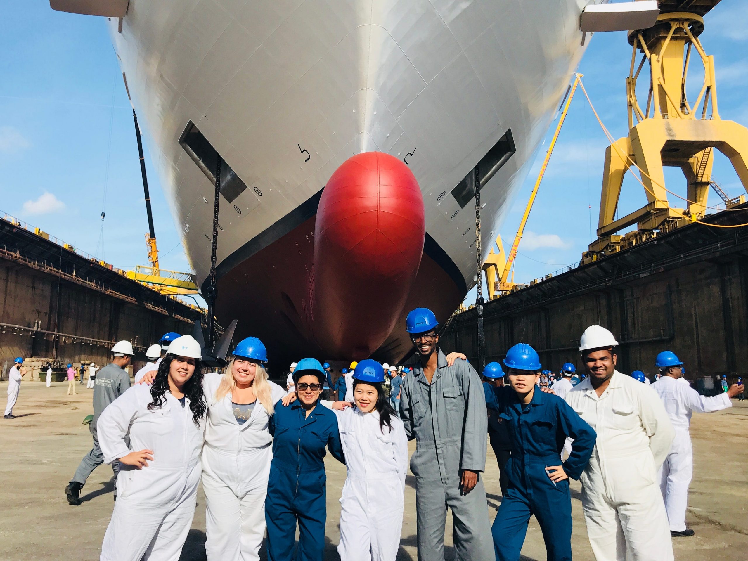 Cruise ship employees standing in front of the boat