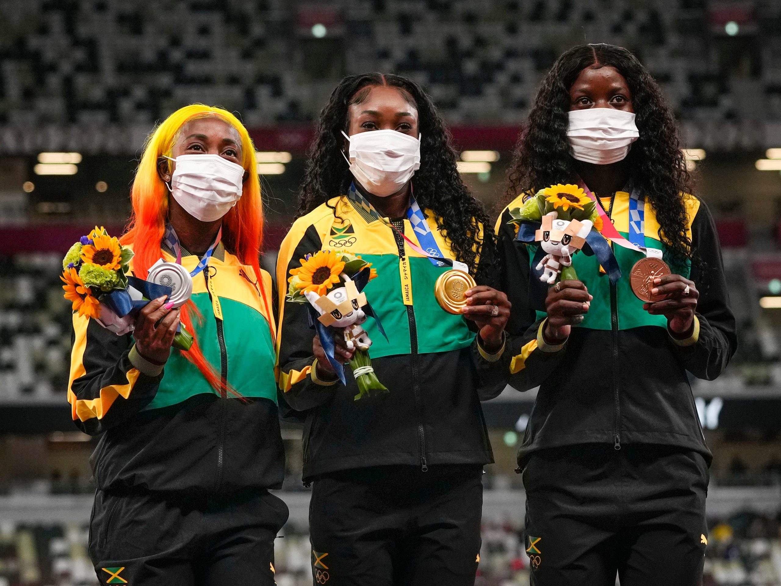 Jamaica's Elaine Thompson-Herah, Shelly-Ann Fraser-Pryce, and Shericka Jackson pose together after sweeping the Olympic podium during the Tokyo Games.