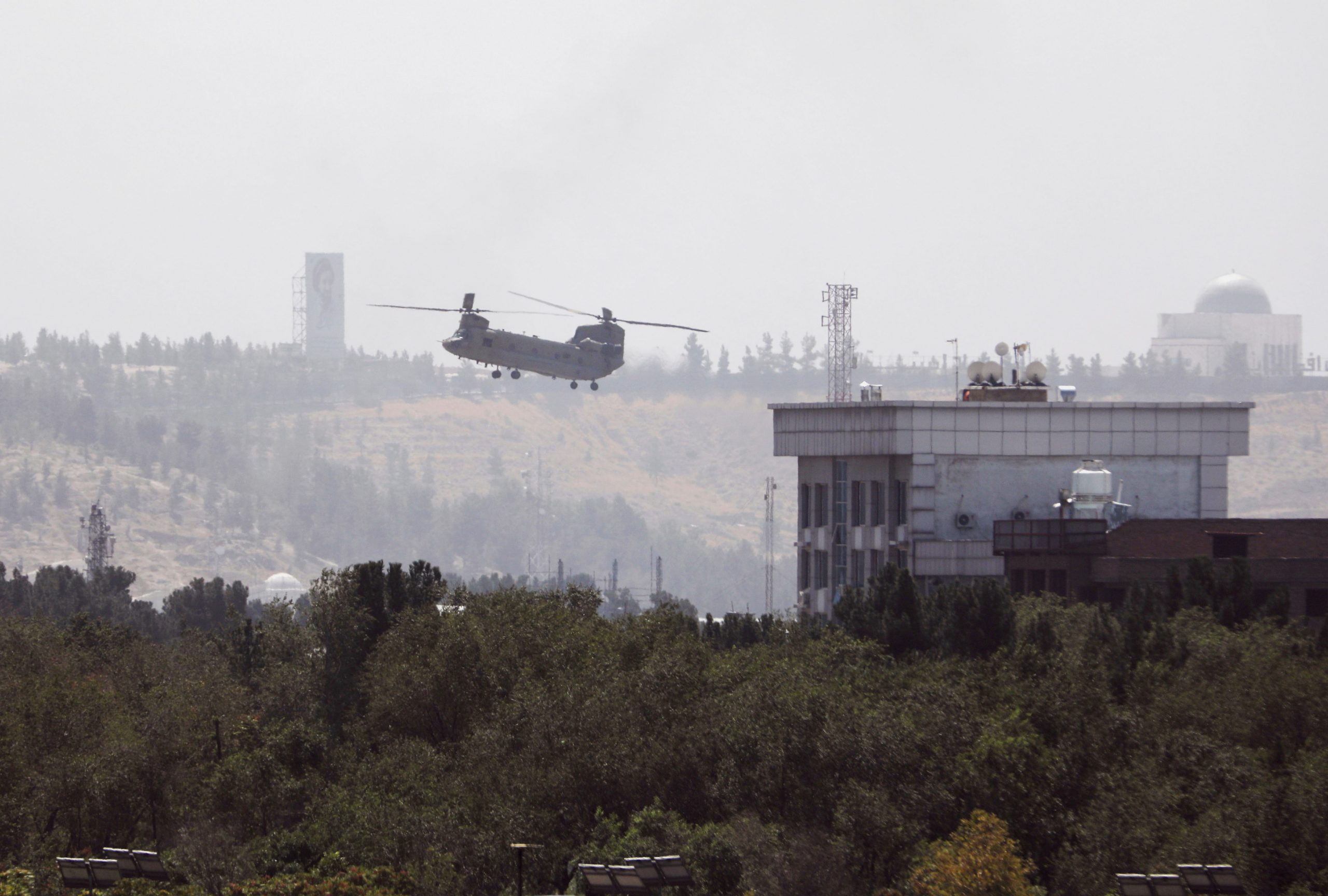 A U.S. Chinook helicopter flies near the U.S. Embassy in Kabul, Afghanistan, Sunday, Aug. 15, 2021. Helicopters are landing at the U.S. Embassy in Kabul as diplomatic vehicles leave the compound amid the Taliban advanced on the Afghan capital.