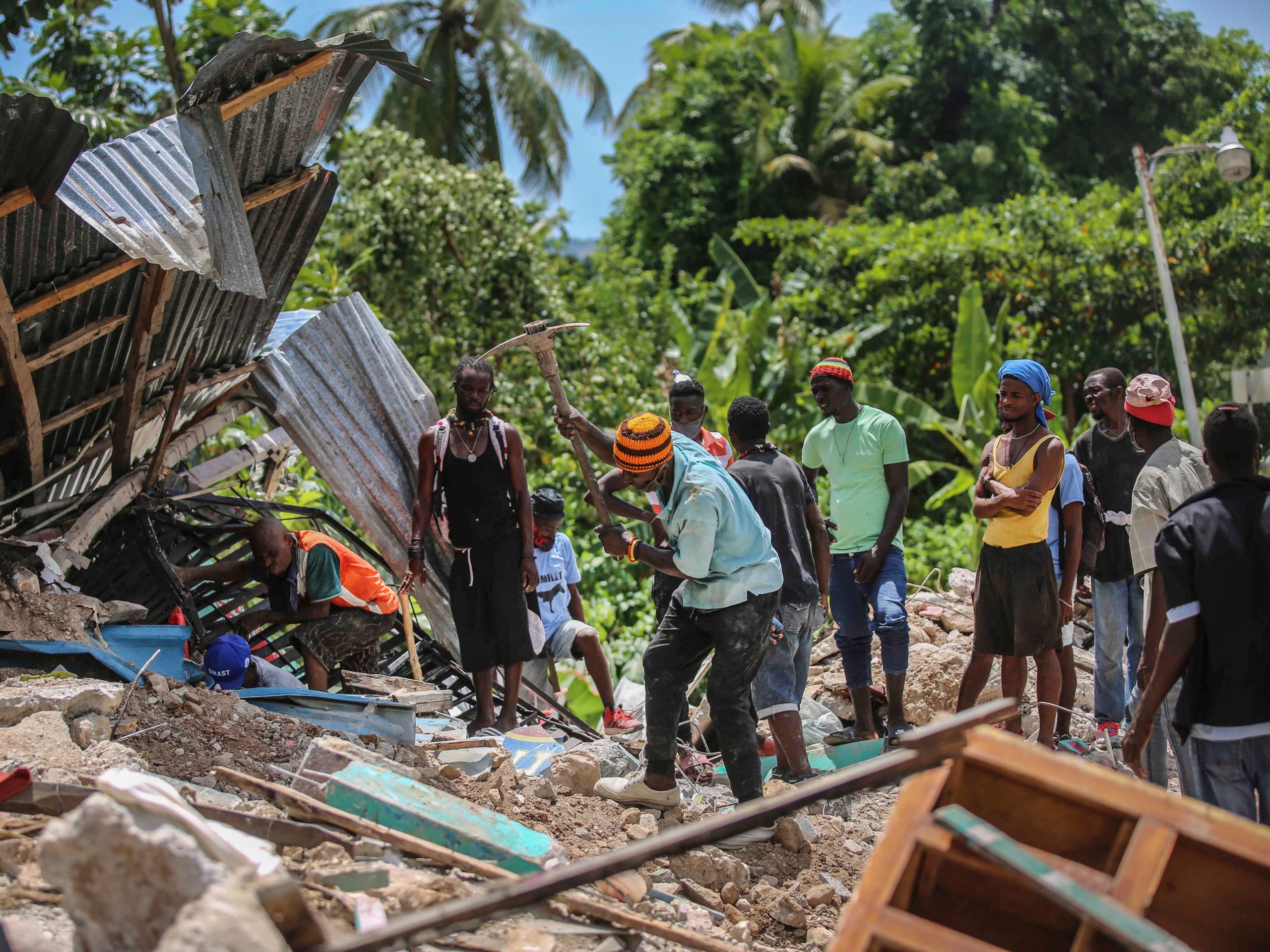 Locals search for victims in a home destroyed by an earthquake in Camp-Perrin, Les Cayes, Haiti, Sunday, Aug. 15, 2021.