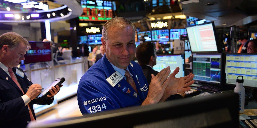 A stock trader claps at the end of trade at the New York Stock Exchange