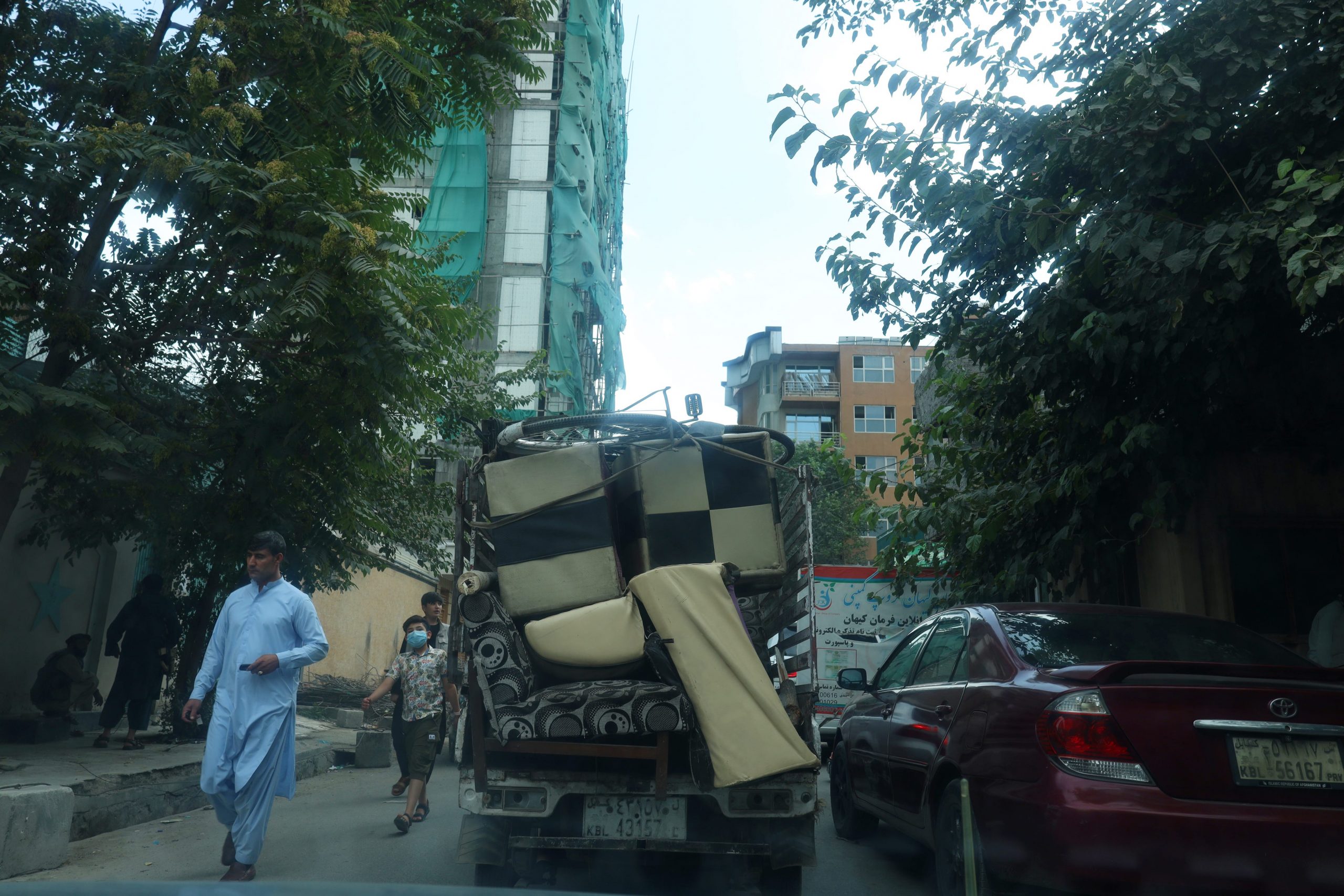 a truck packed with belongings drives through kabul