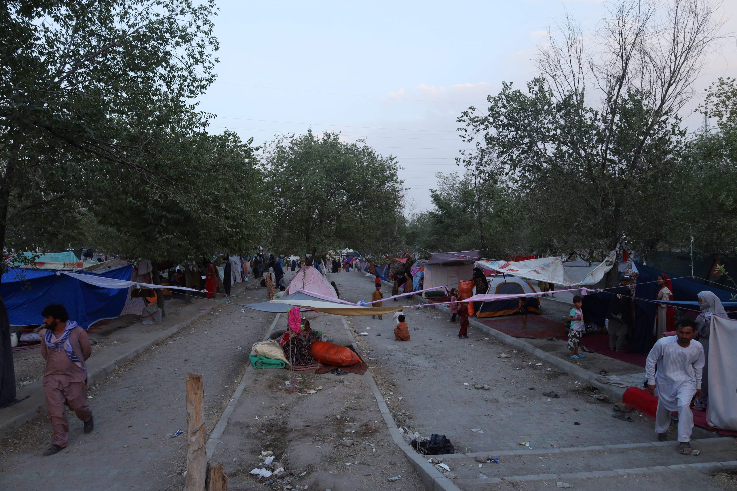 tents stretch across the sand and concrete at a makeshift refugee camp in kabul