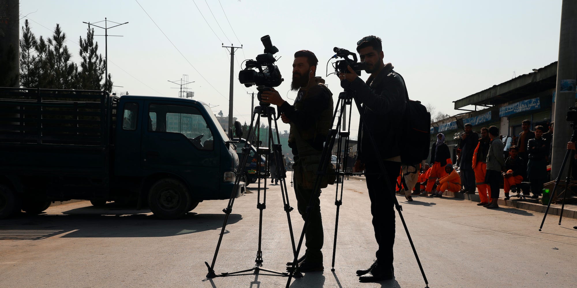 Afghan journalists film at the site of a bombing attack in Kabul, Afghanistan