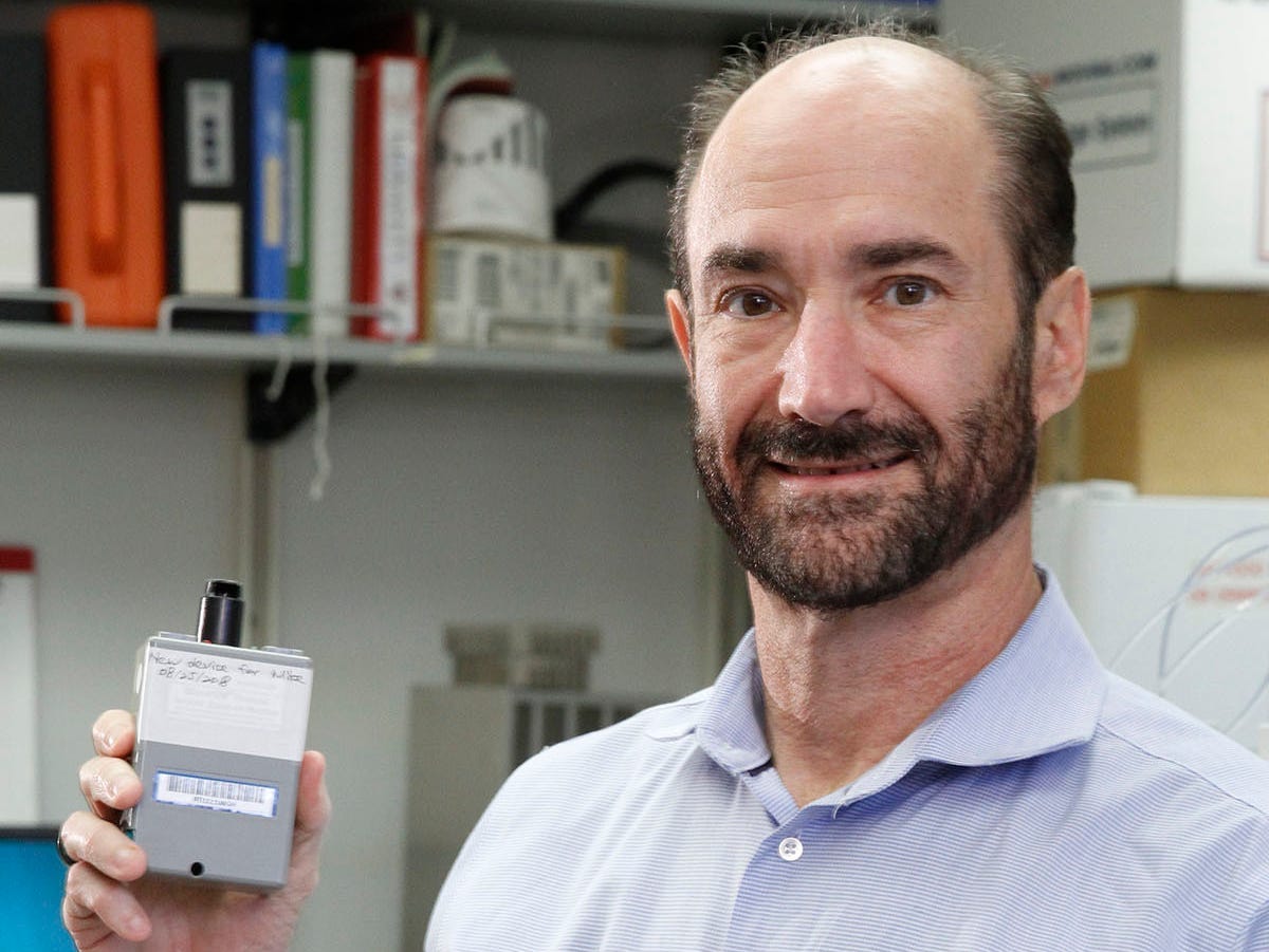 Stanford's Michael Snyder holds up a monitor.