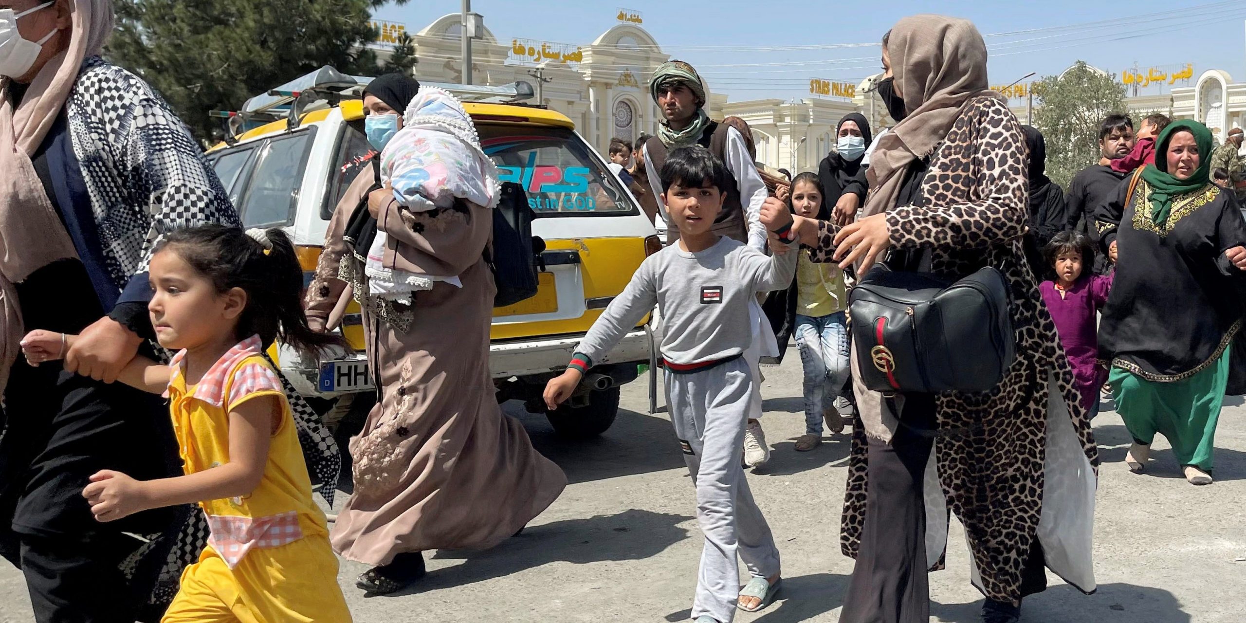 Women with their children try to get inside Hamid Karzai International Airport in Kabul, Afghanistan August 16, 2021.