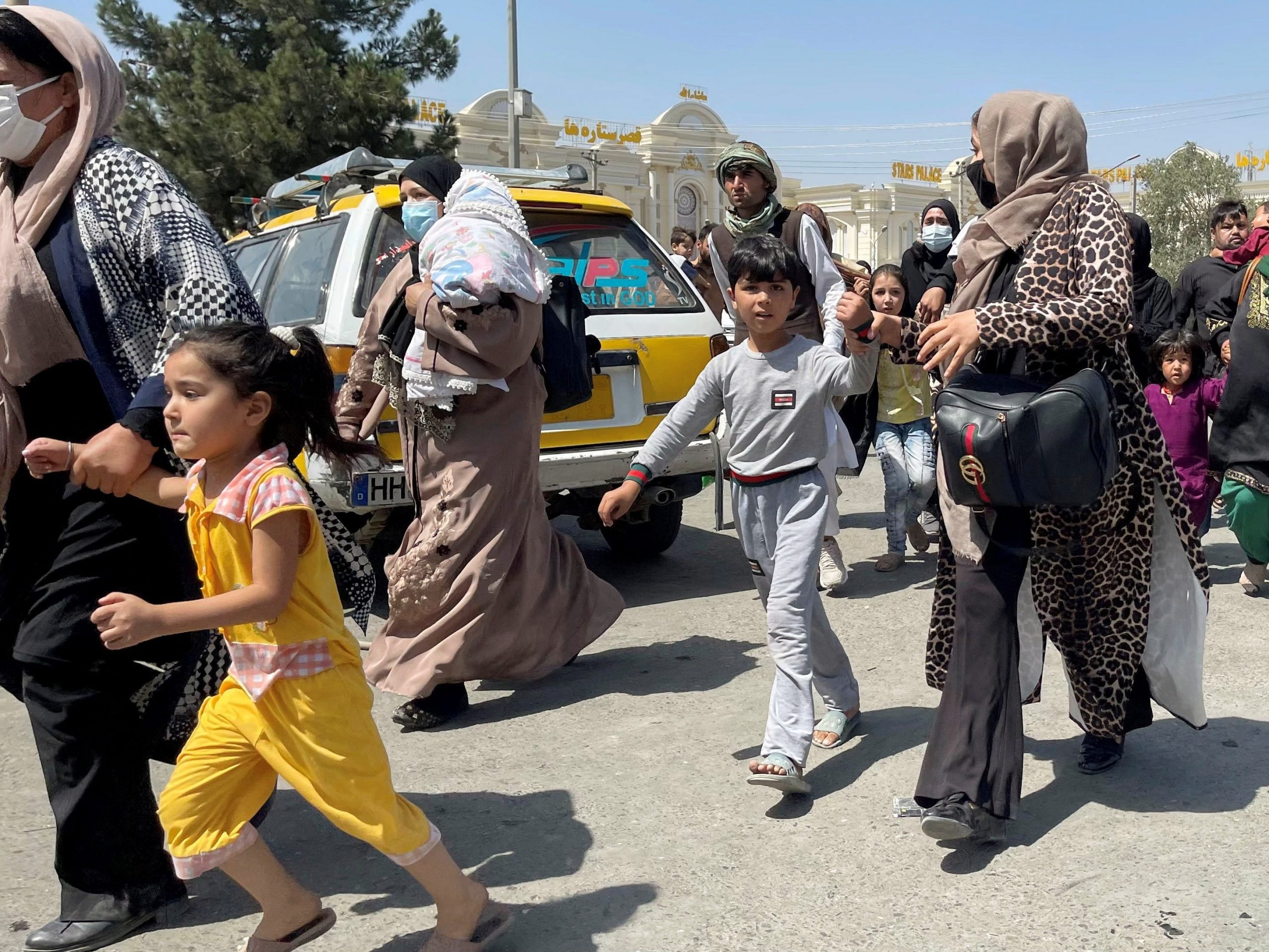 Women with their children try to get inside Hamid Karzai International Airport in Kabul, Afghanistan August 16, 2021.