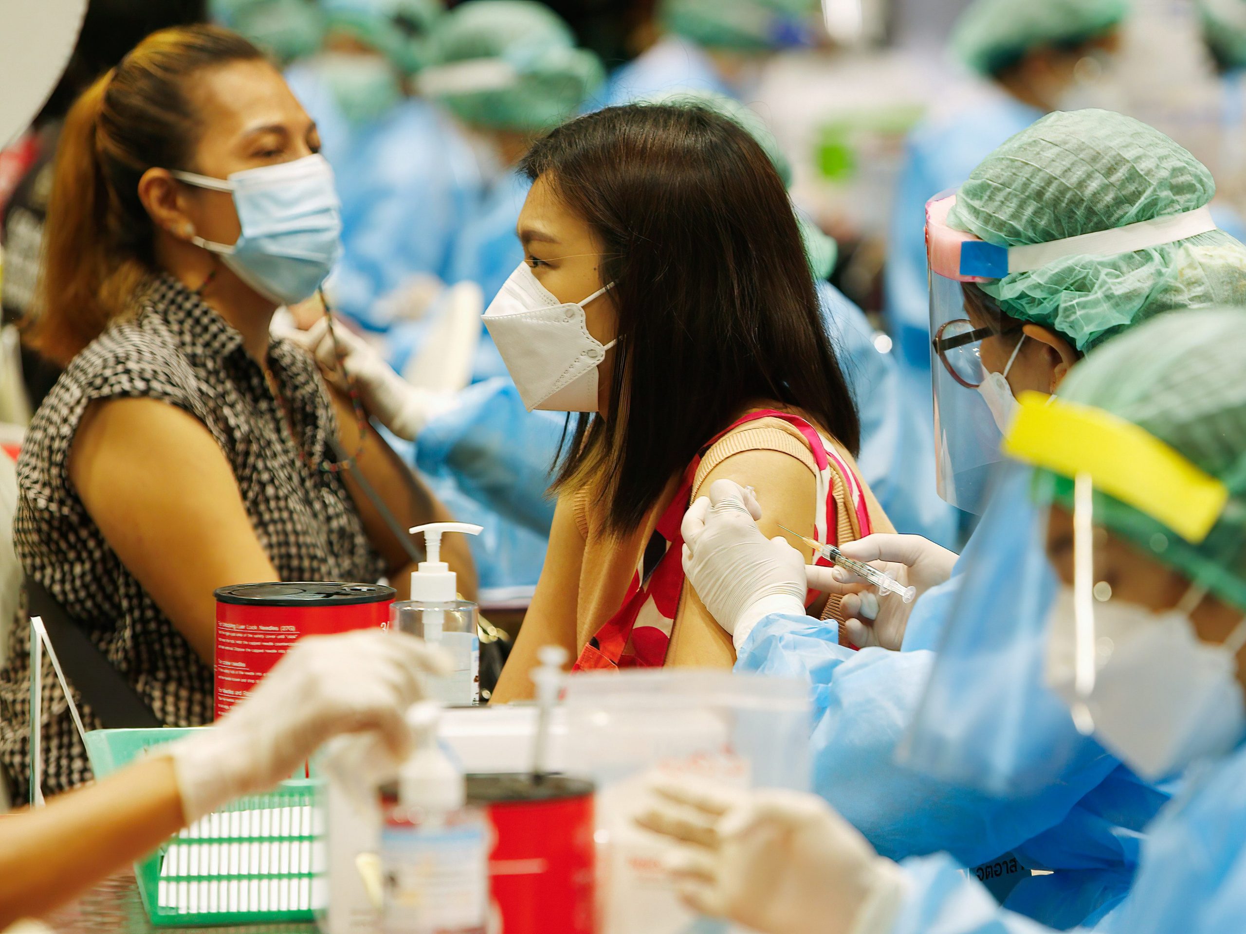 A health workers administer doses of CoronaVac vaccine to people at a vaccination center in Bangkok.