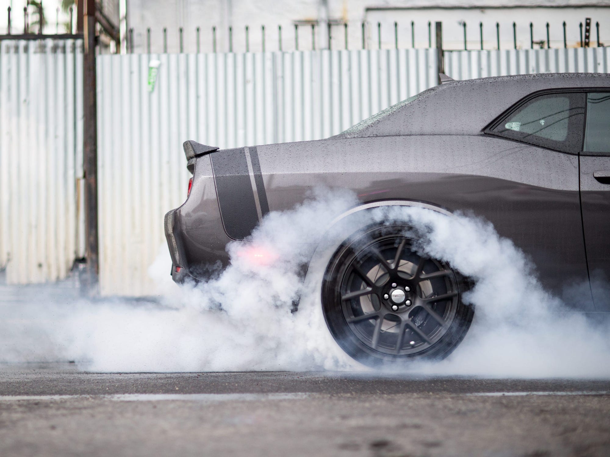 A Mustang with smoke coming from its tires