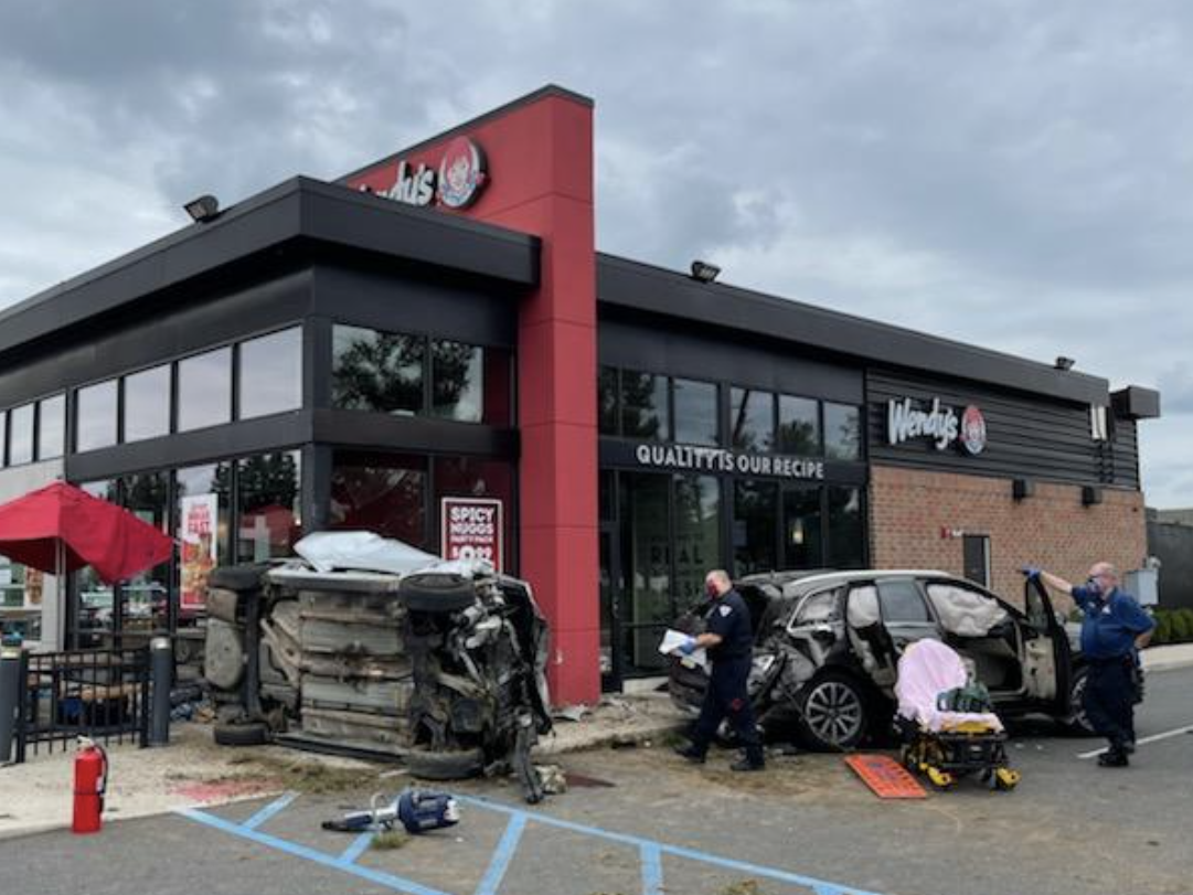 Photo of police examining two cars which smashed into Wendy's restaurant in New Jersey.