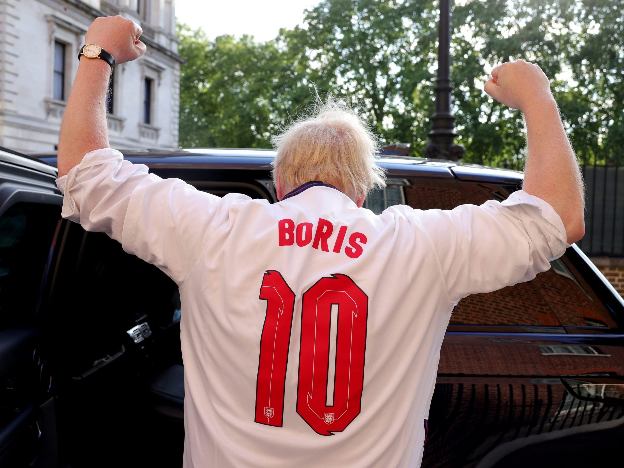 The back of UK Prime Minister Boris Johnson, who is wearing a football t-shirt numbered 10 saying "Boris" on the back.
