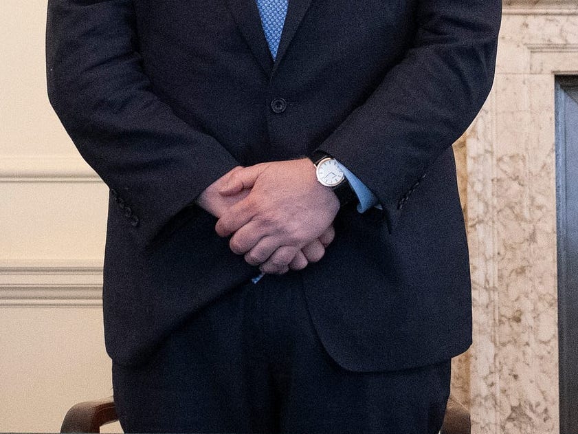 Boris Johnson pauses for a minute's silence at 11am to mark the victims of the Plymouth shootings. A clock behind him says 11am, while his wristwatch shows 11.14am.