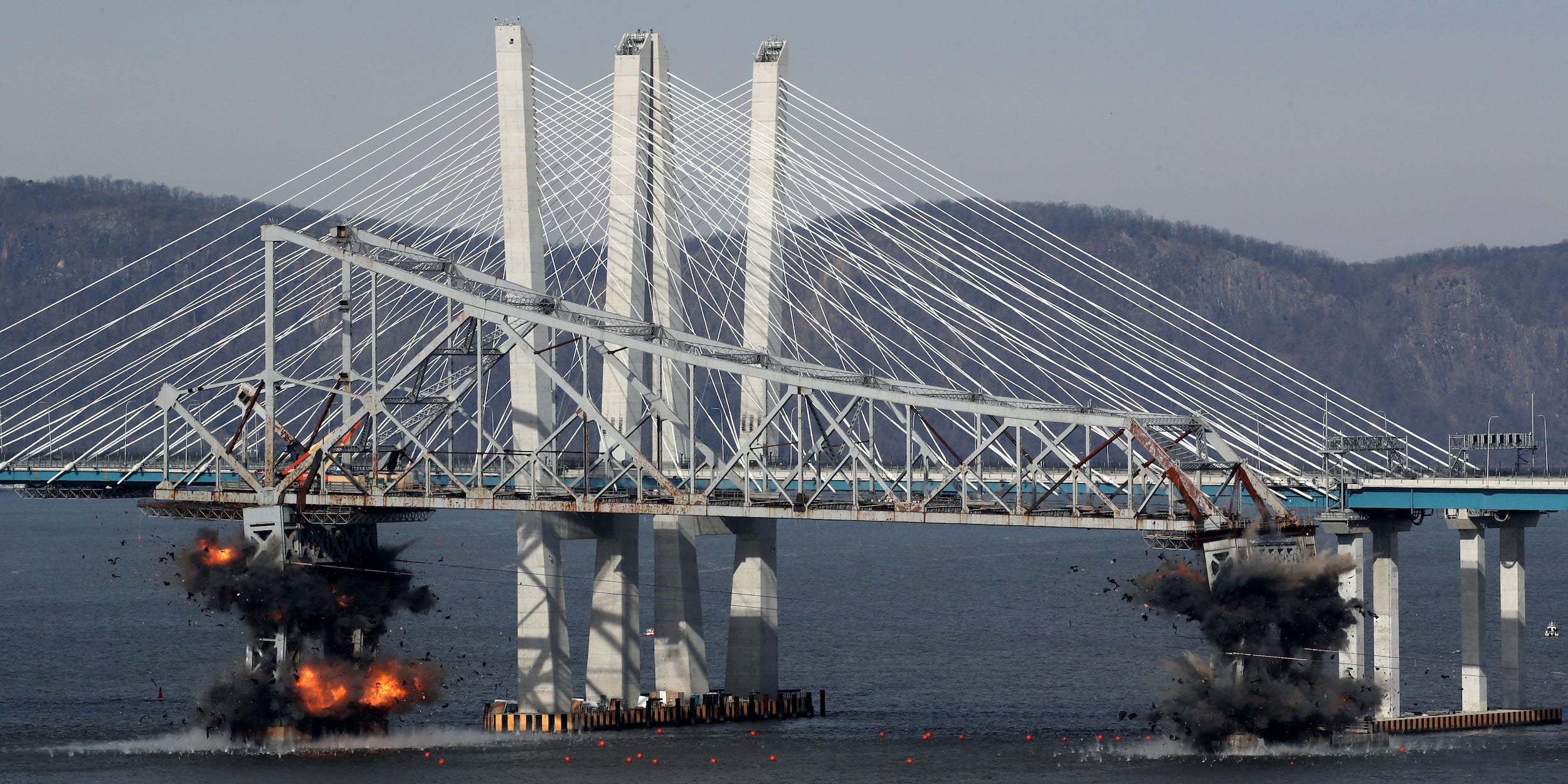 The east anchor span of the old Tappan Zee Bridge is demolished by explosives into the Hudson River in front of the new Mario Cuomo Bridge in Tarrytown, New York, U.S., January 15, 2019.