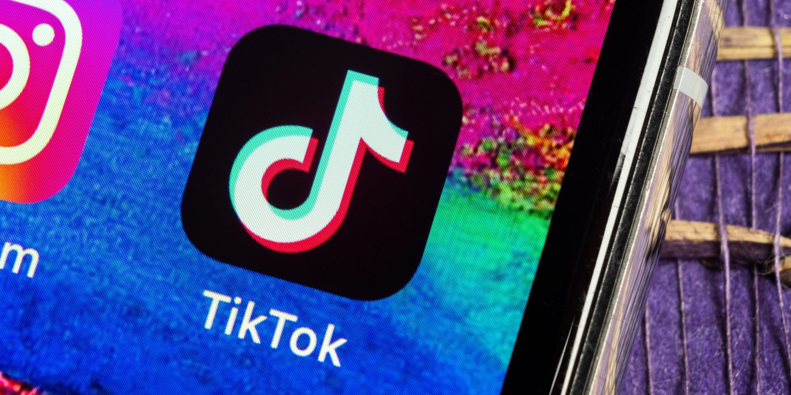 The TikTok app logo on an iPhone with a colorful background.