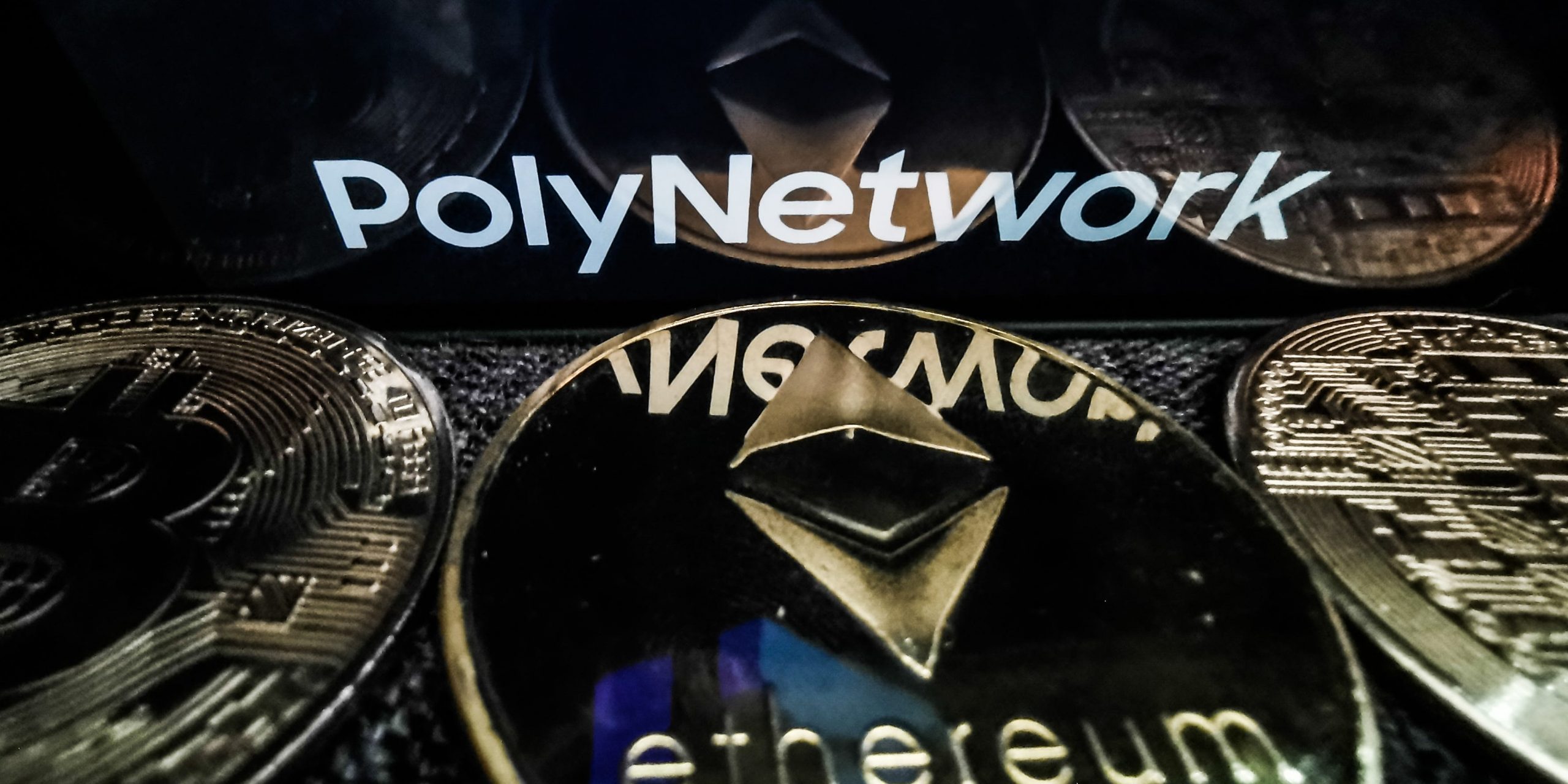 Poly Network logo displayed on a phone screen and representation of Ethereum cryptocurrency is seen in this illustration photo taken in Sulkowice, Poland on August 12, 2021.