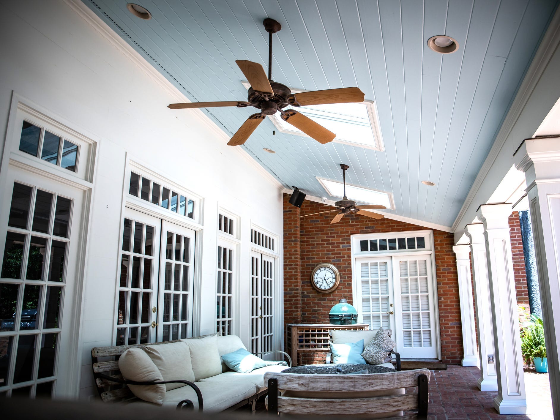 A patio with a large portico and ceiling fans