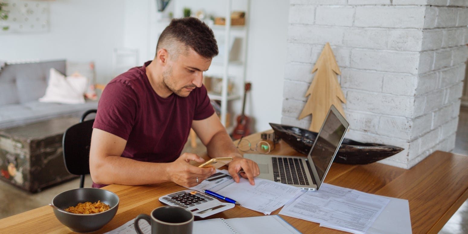 Young man at home, paying bills online