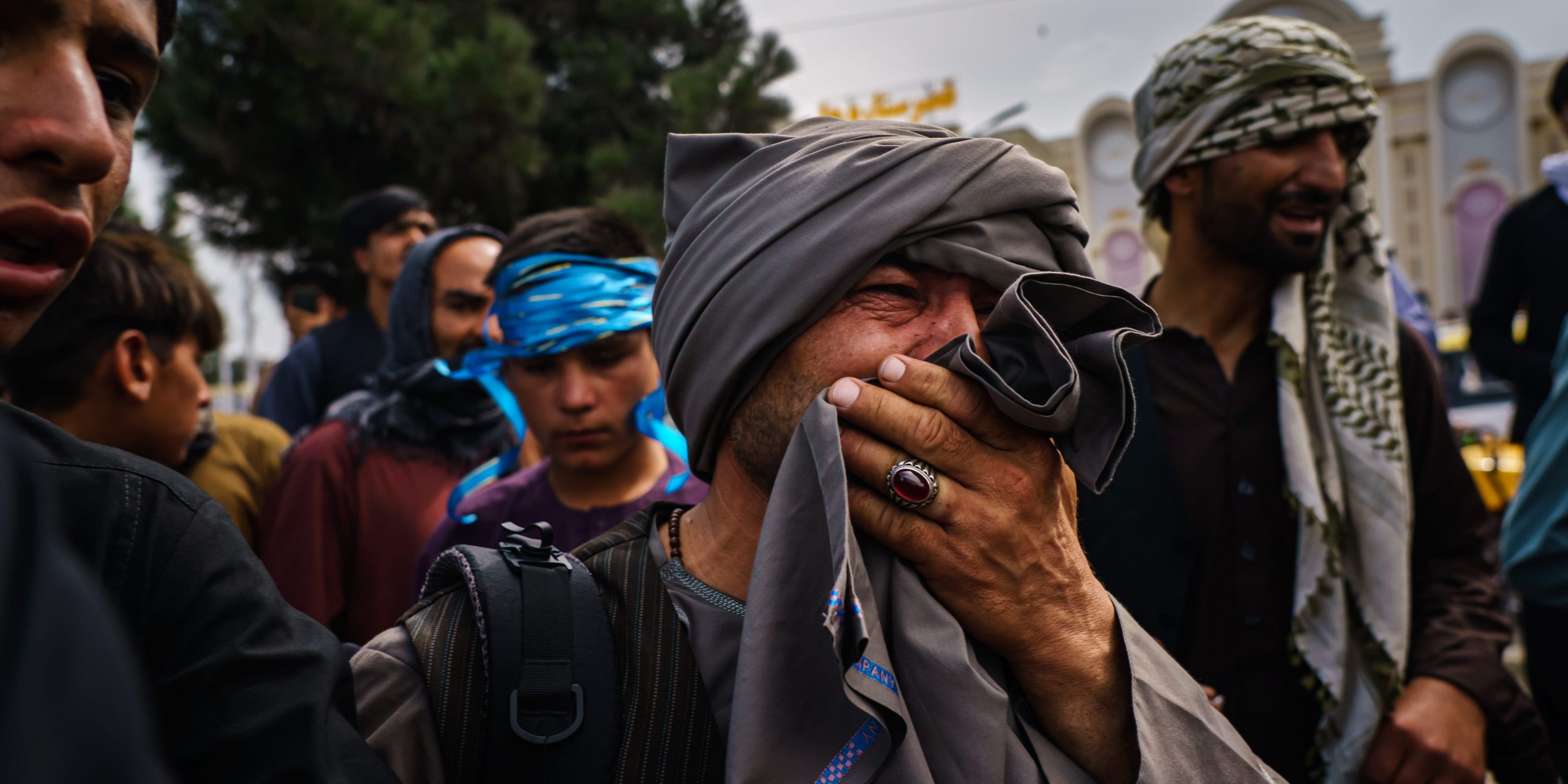 A man cries as he watches fellow Afghans get wounded by Taliban fighters