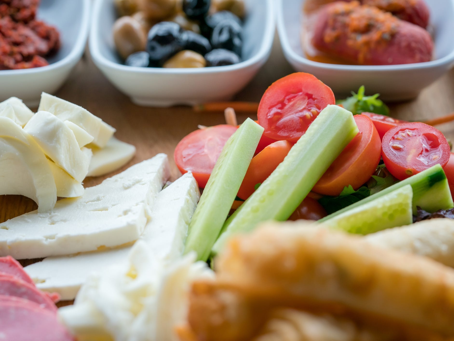 Close up shot of cheeses and vegetables.