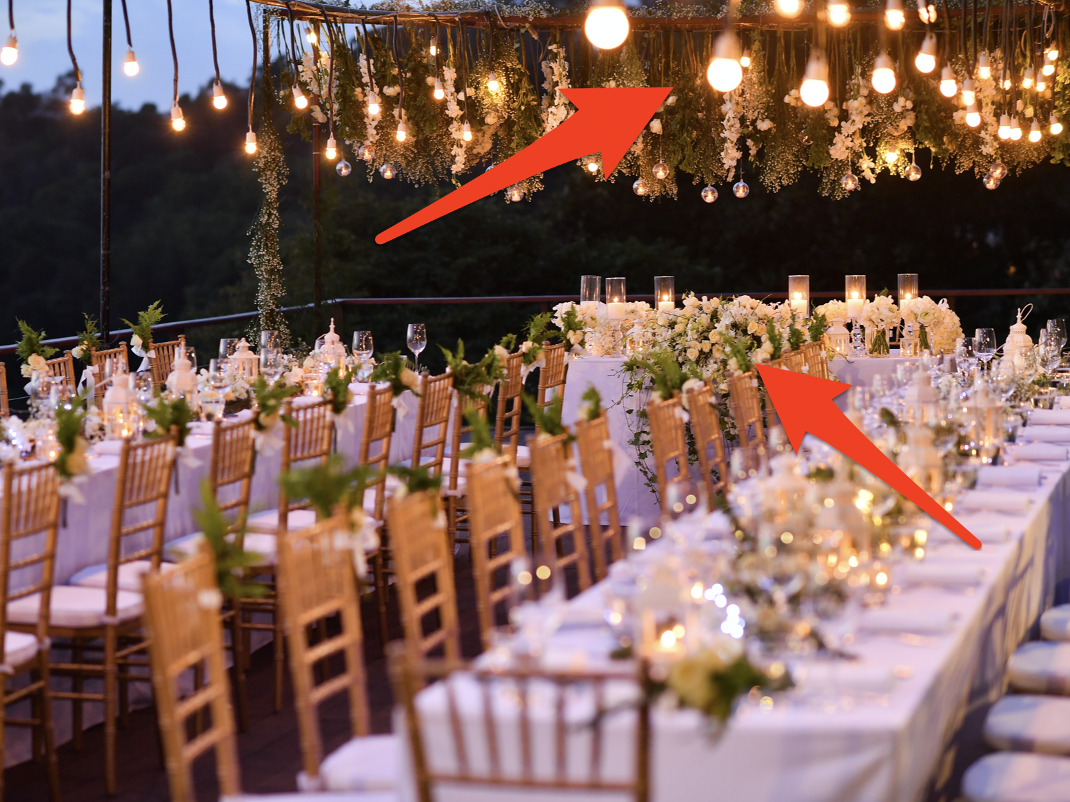 red arrows pointing to fairy lights and flowers at a decorated wedding venue